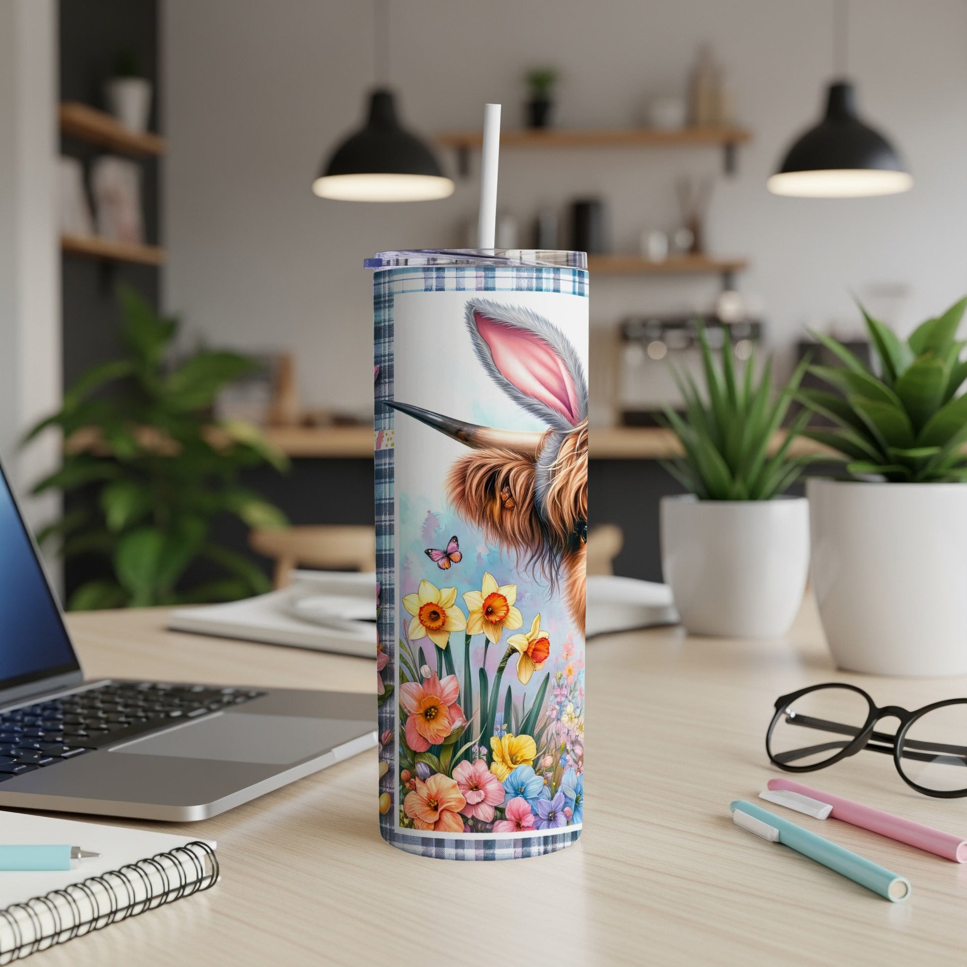 Highland cow with bunny ears and floral design on a plaid tumbler.