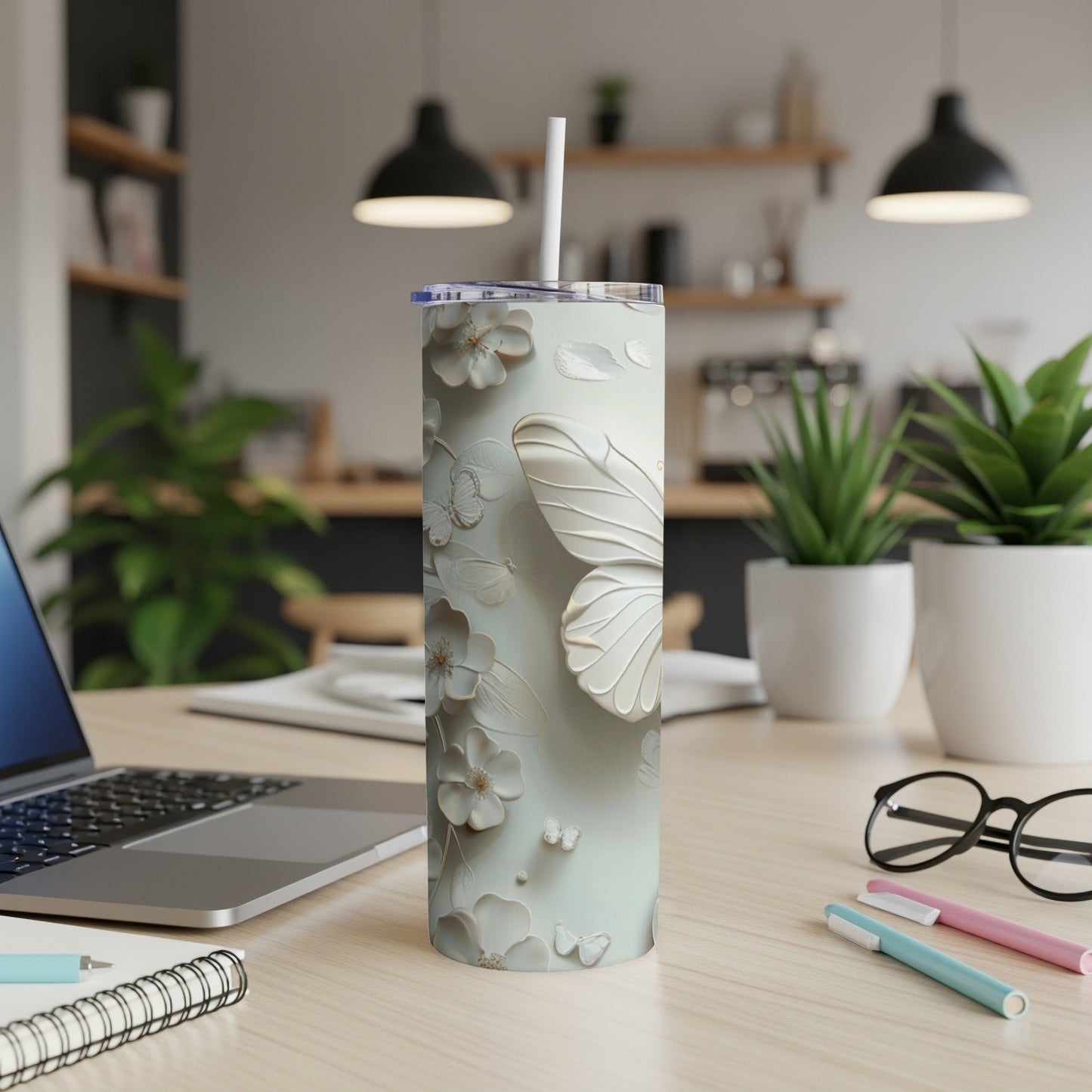 White butterfly floral pattern on a tall, slim tumbler with a straw.