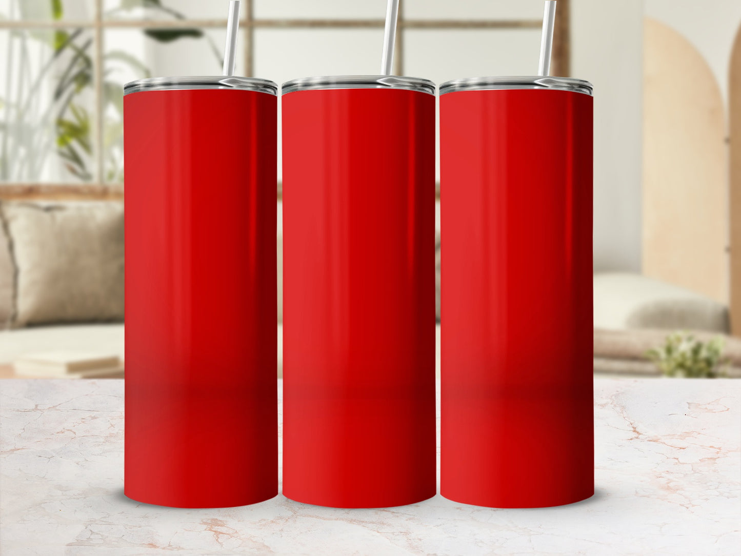 Three red tumblers with straws stand on a marble surface.