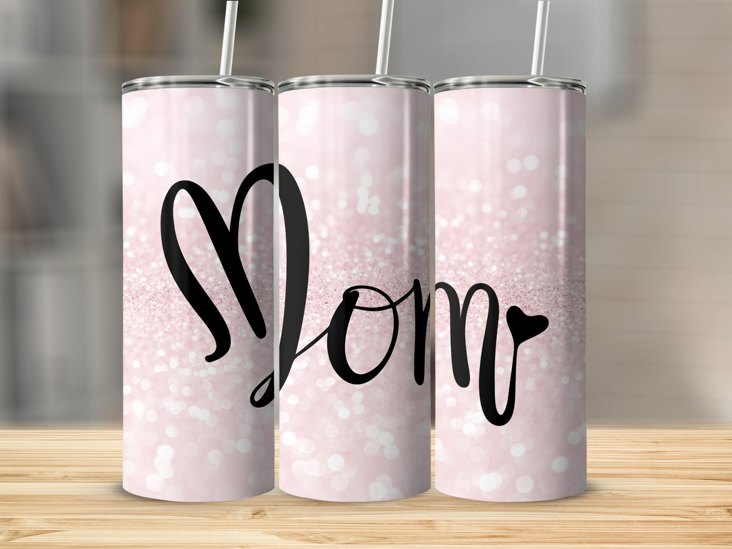 Pink glitter tumbler with "Mom" in black script.