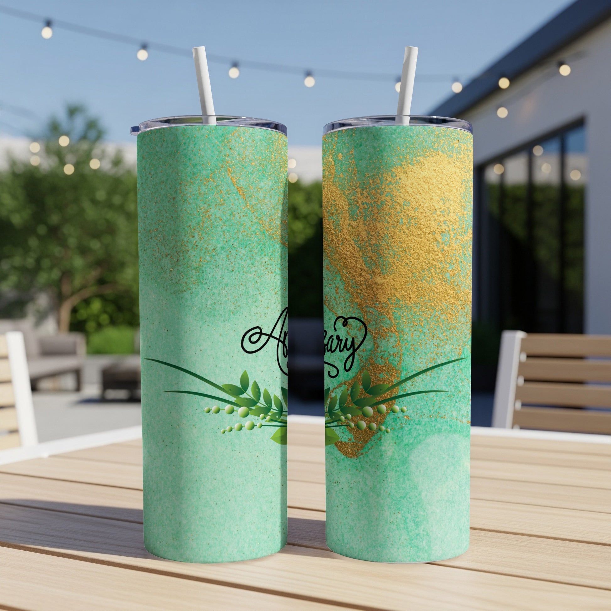 Two green tumblers with gold glitter and leafy branches, one saying "Anniversary."