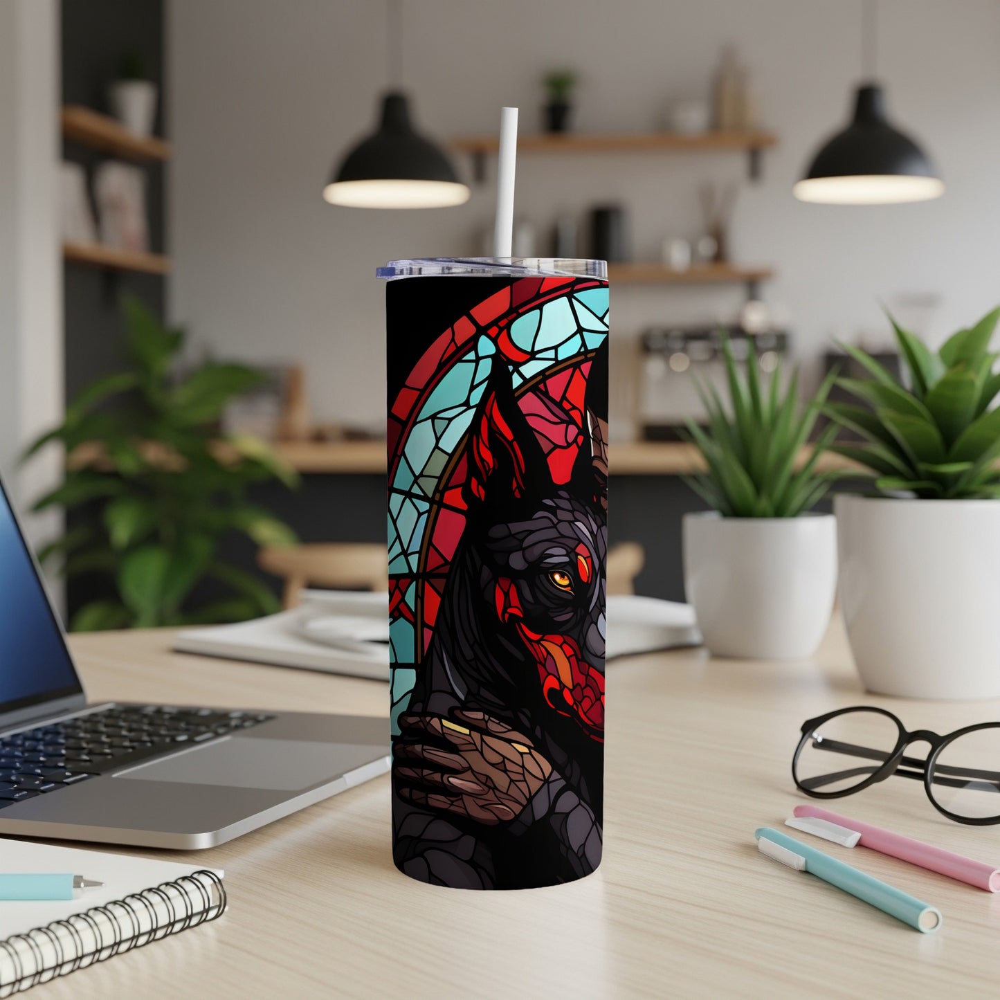 Black tumbler with stained glass wolf design and white straw on a wooden desk.