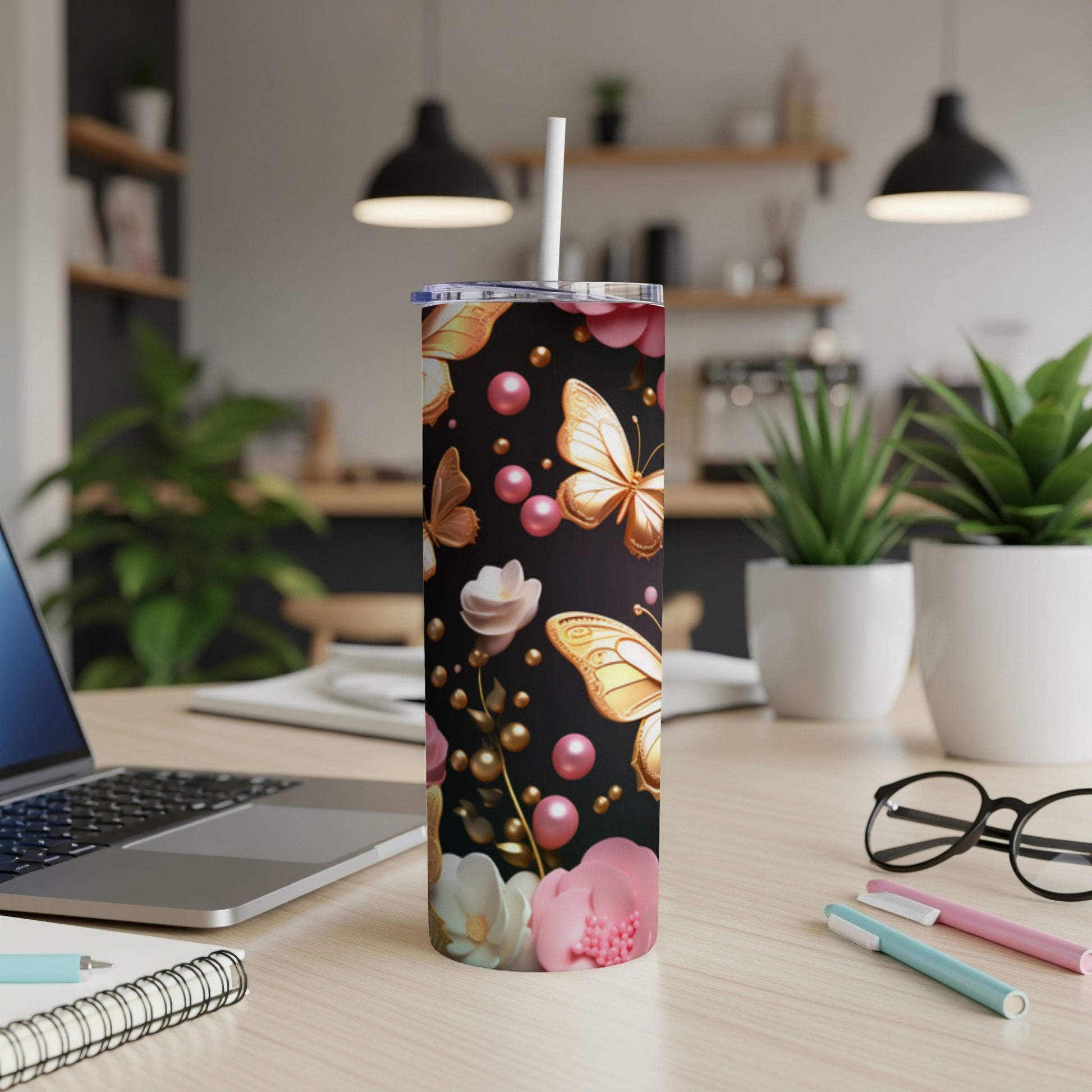 Gold and pink butterflies and flowers on a black tumbler with straw.