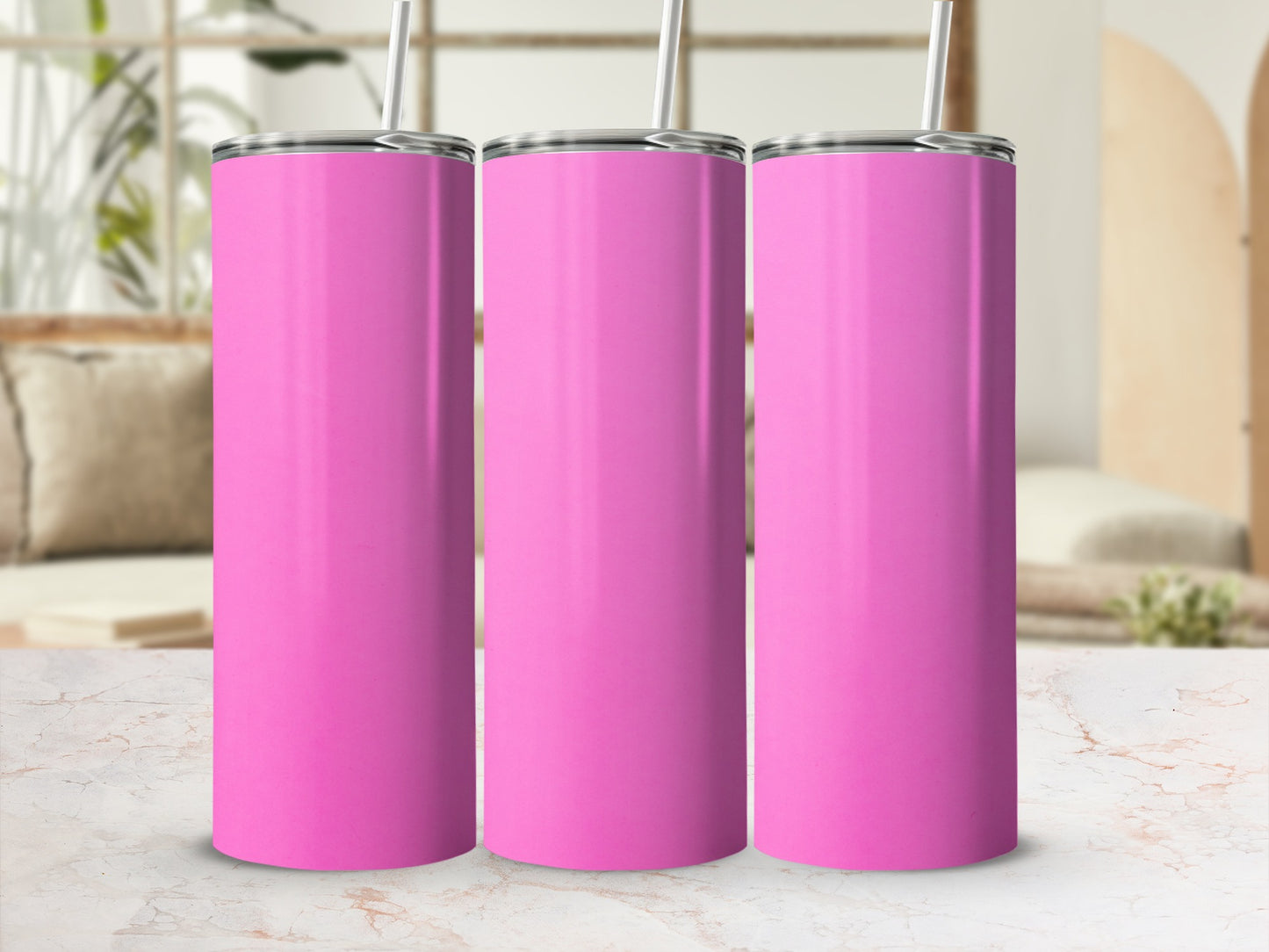 Three pink tumblers with straws on a marbled surface.