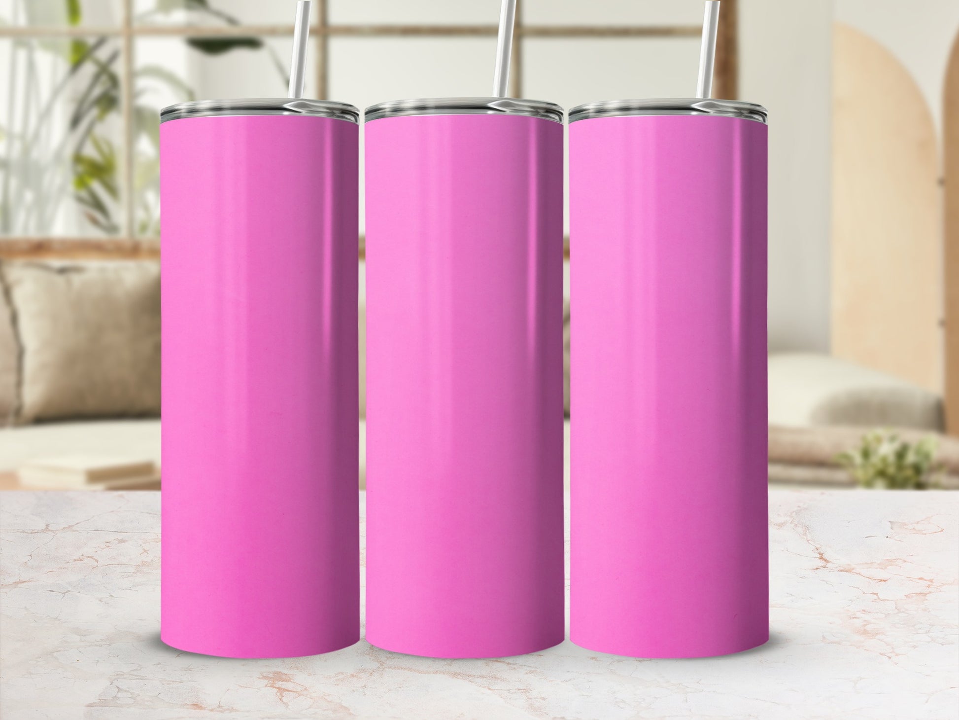 Three pink tumblers with straws on a marbled surface.