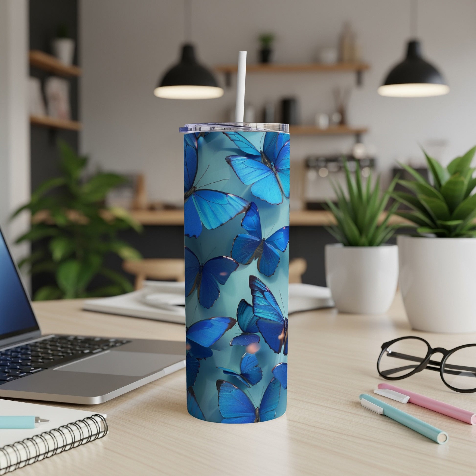 Blue butterflies adorn a white insulated tumbler with a straw.