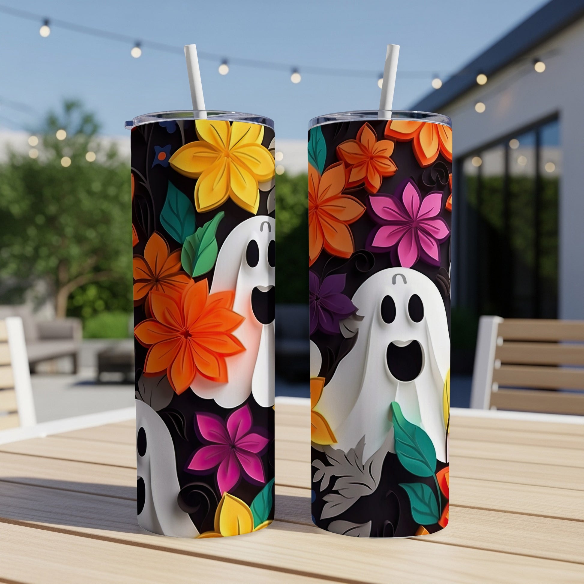 Two tumblers with a Halloween ghost and floral design on a table.