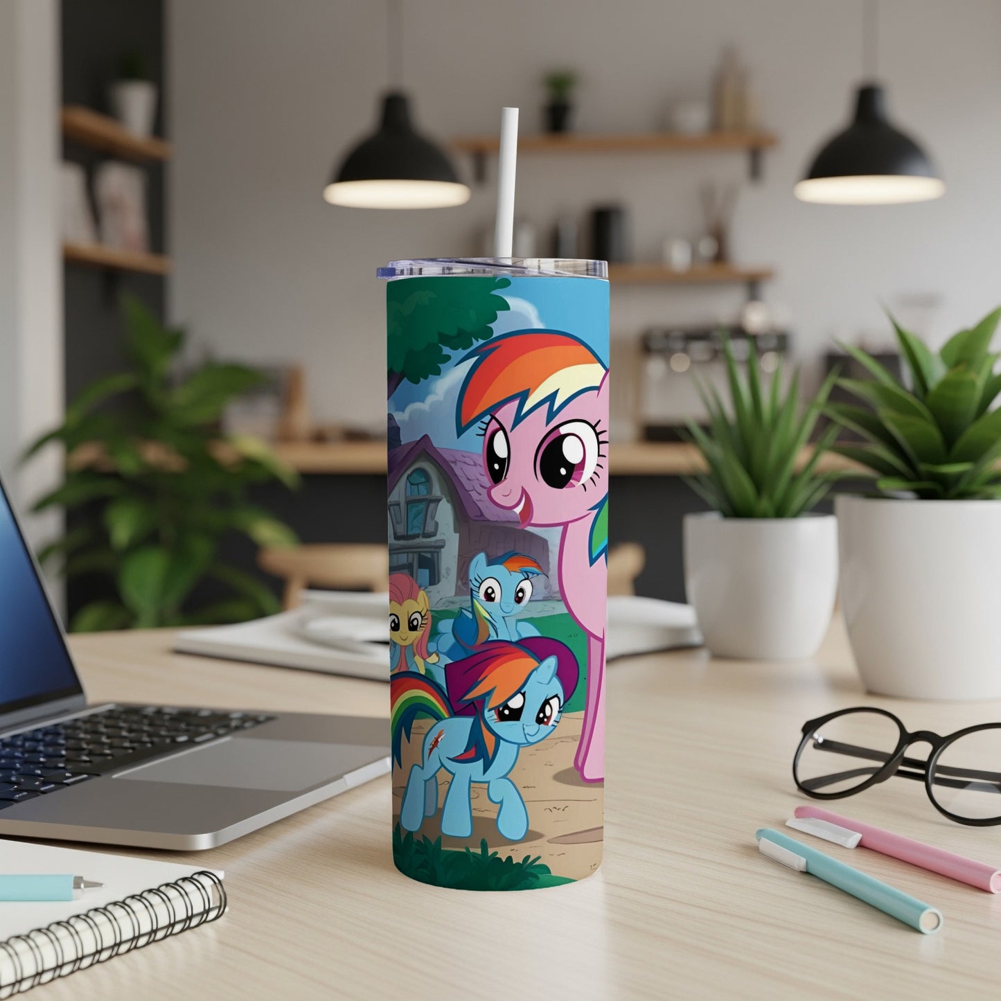 My Little Pony characters on a colorful tumbler cup on a desk.