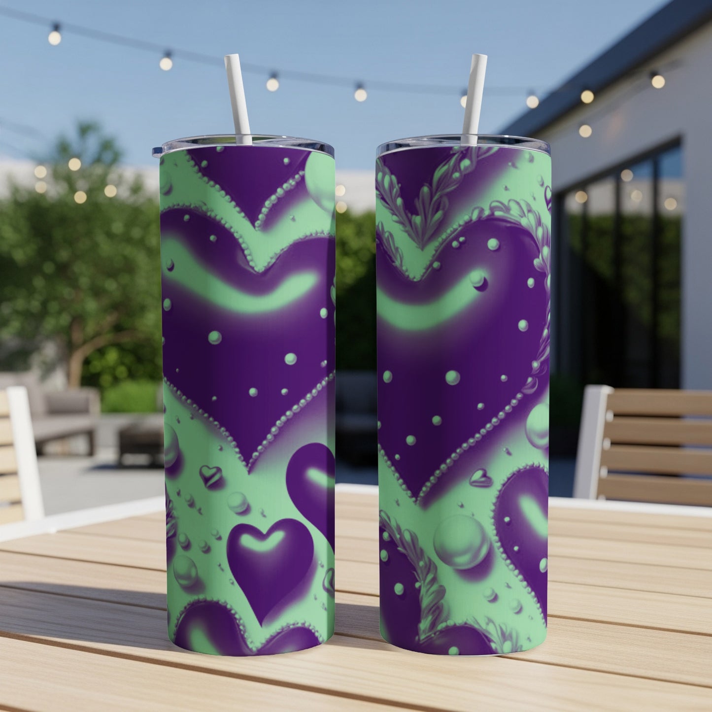 Two purple and green tumblers with a heart pattern, on a table outdoors.