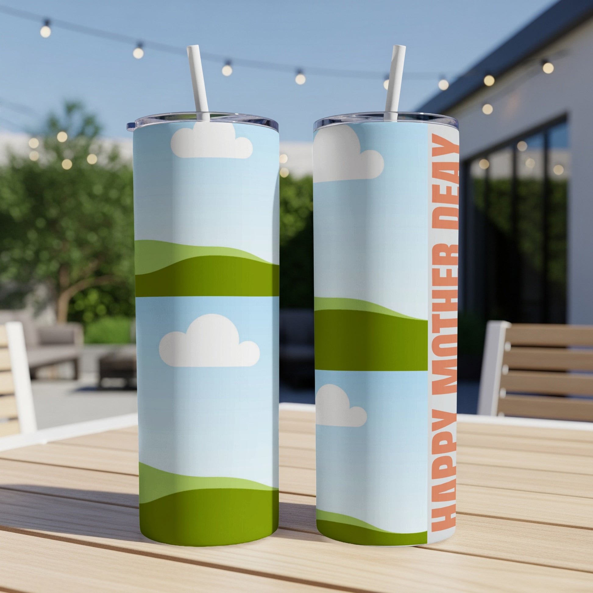 Two tumblers with a sky, cloud, and rolling green hills design, one with text.
