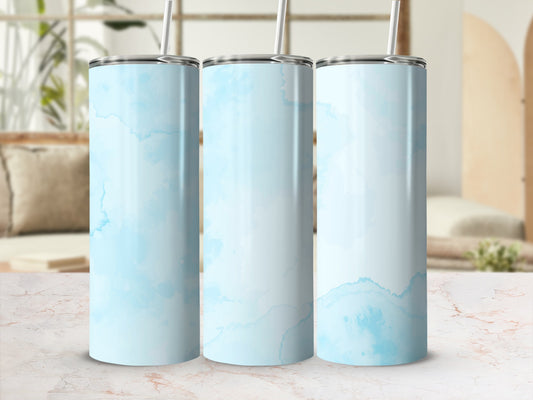 Three blue watercolor patterned tumblers with straws on a marble surface.