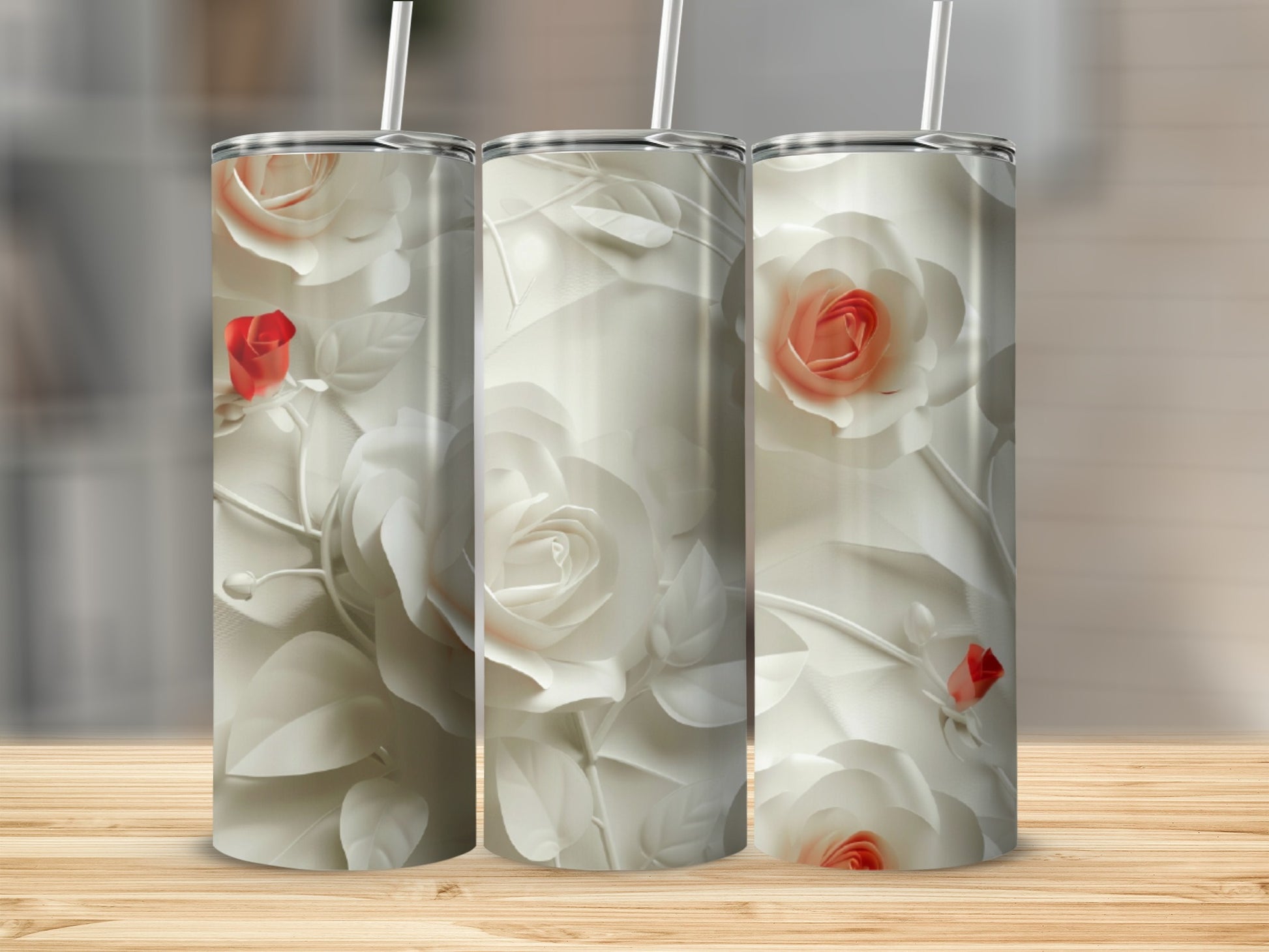 Three white rose patterned tumblers on a wooden surface.