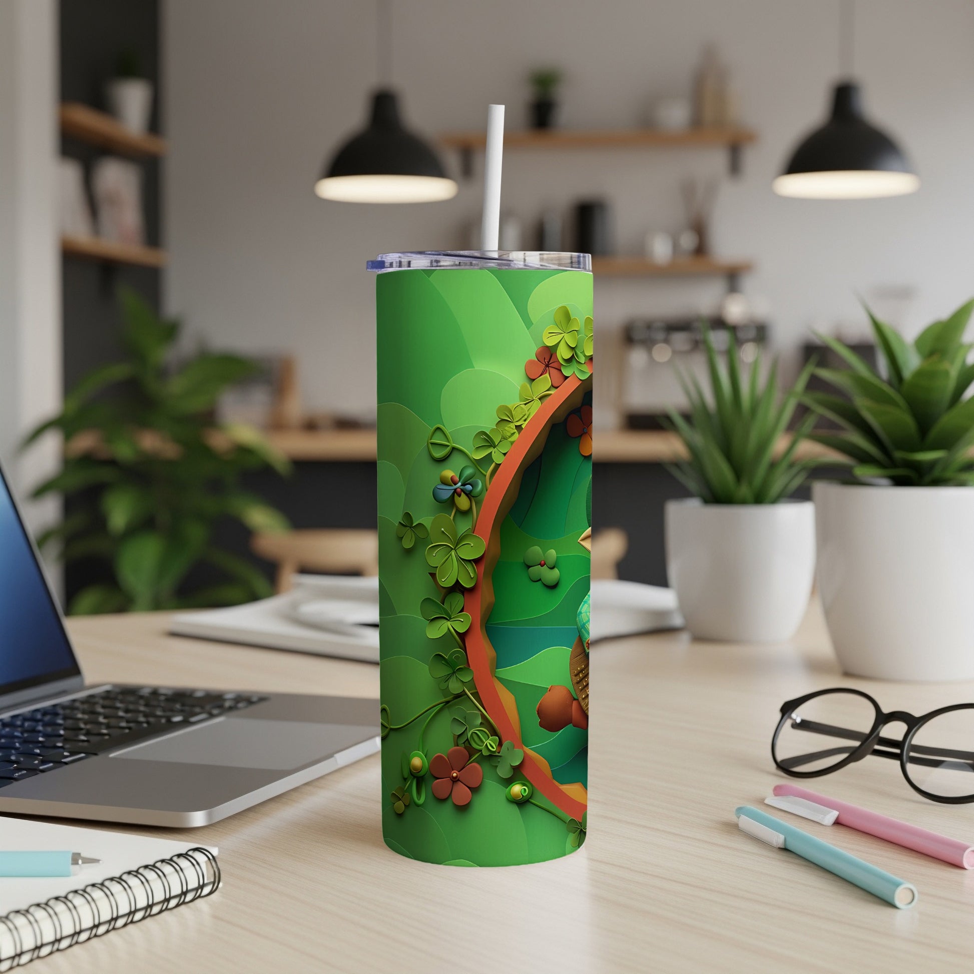 Green tumbler with shamrocks and floral accents, on a desk.