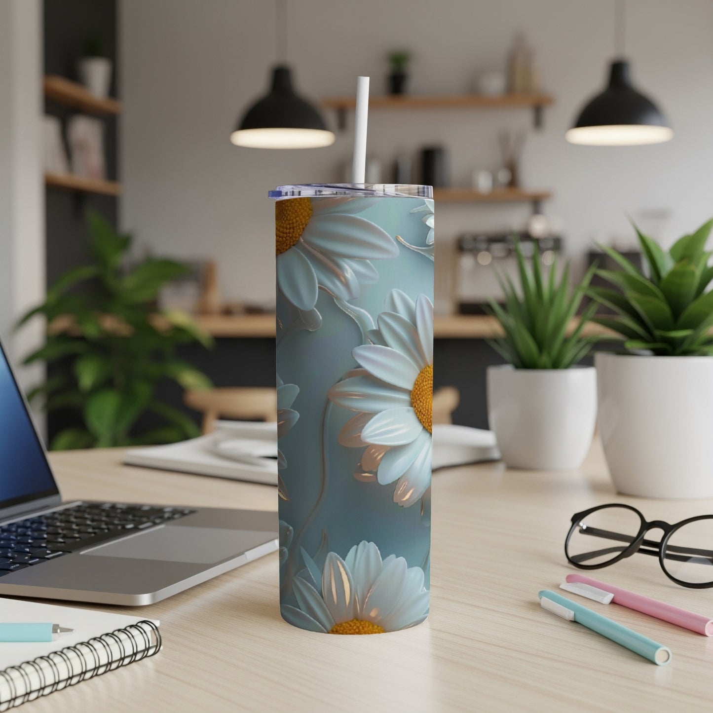 Blue tumbler with light blue daisies and green leaf pattern.