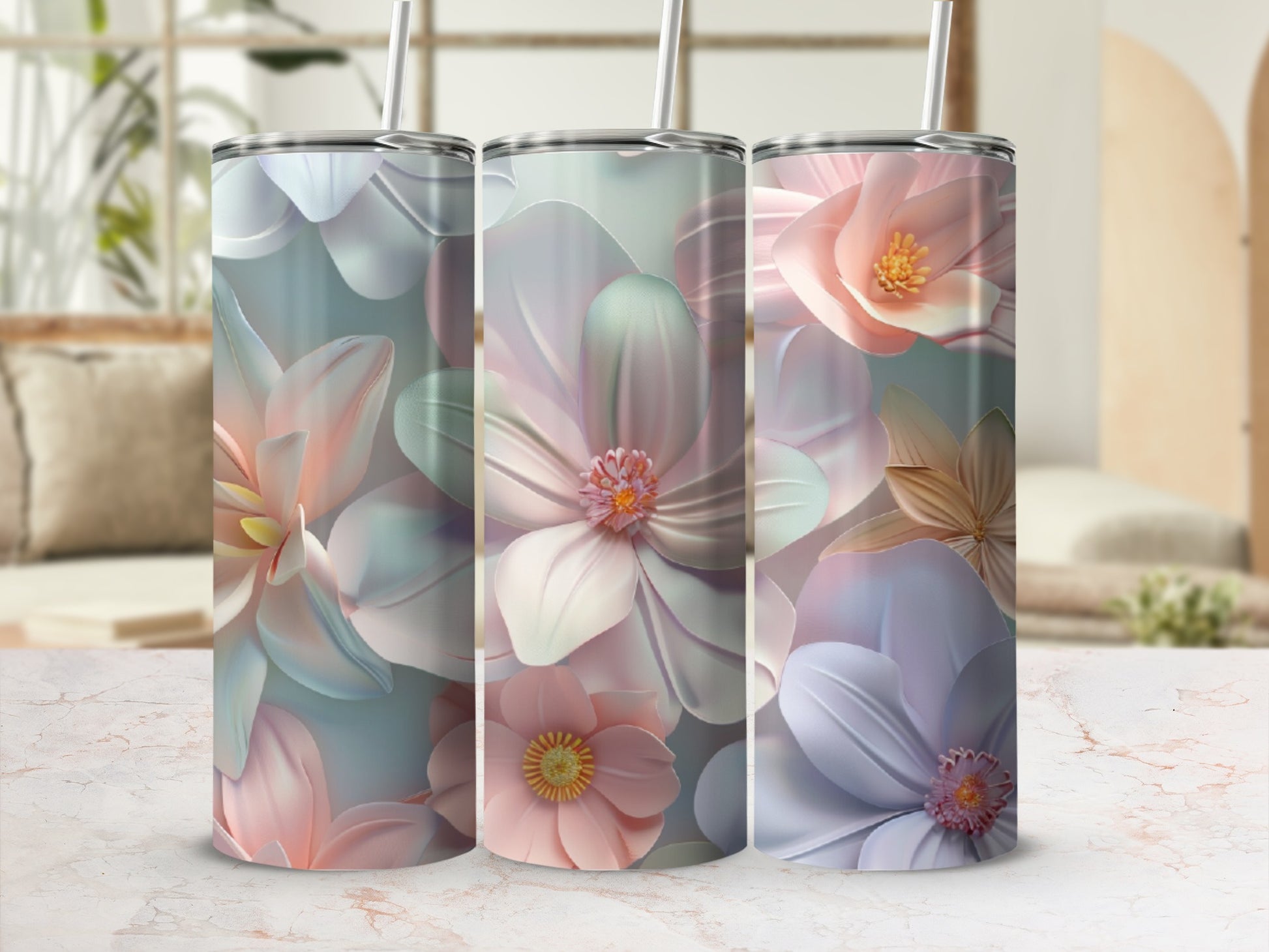 Three tumblers with pastel floral designs on a marble surface.