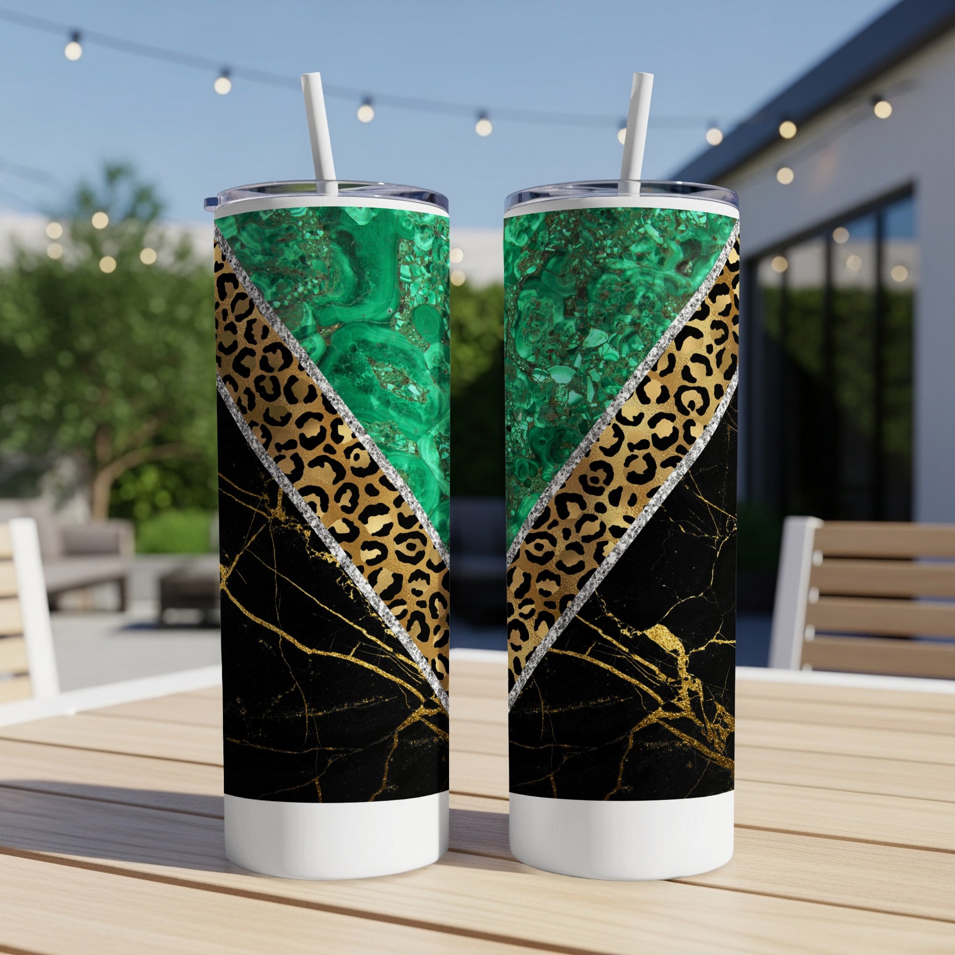 Two tumblers with green marble, leopard print, and gold accents on a table.