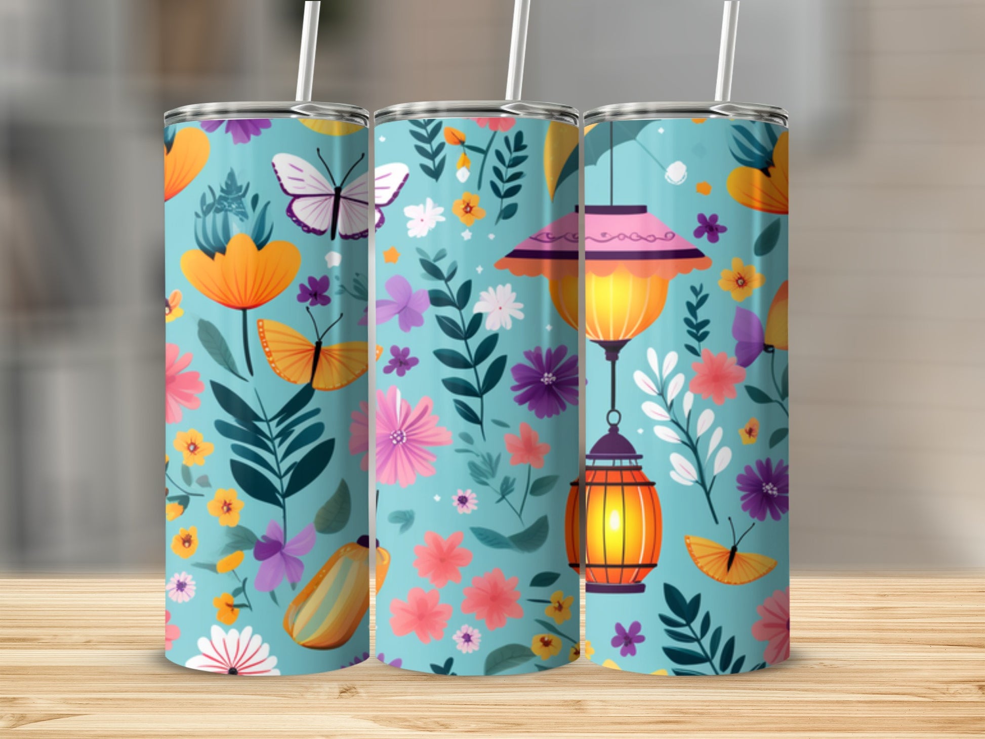 Three teal tumblers with floral and butterfly designs and lanterns.