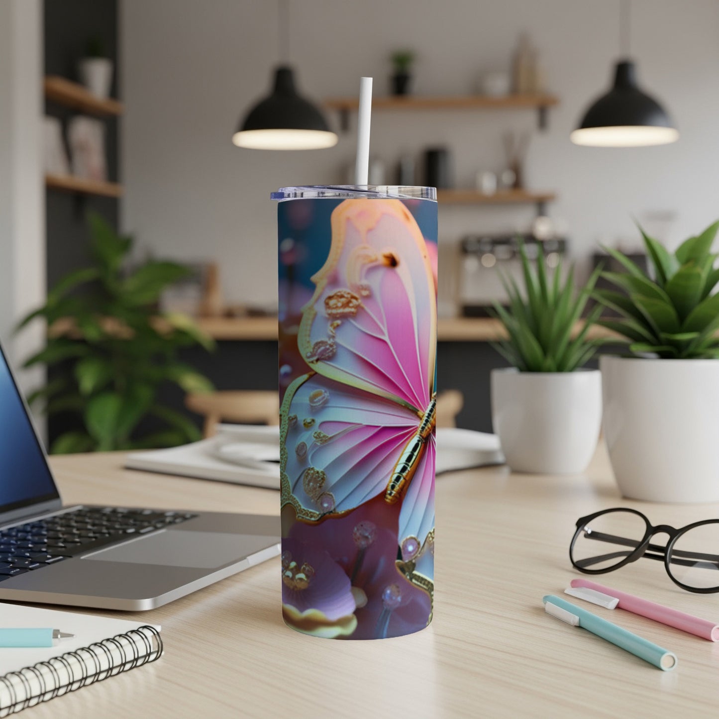 Tall tumbler with a pink and blue butterfly design on a desk.