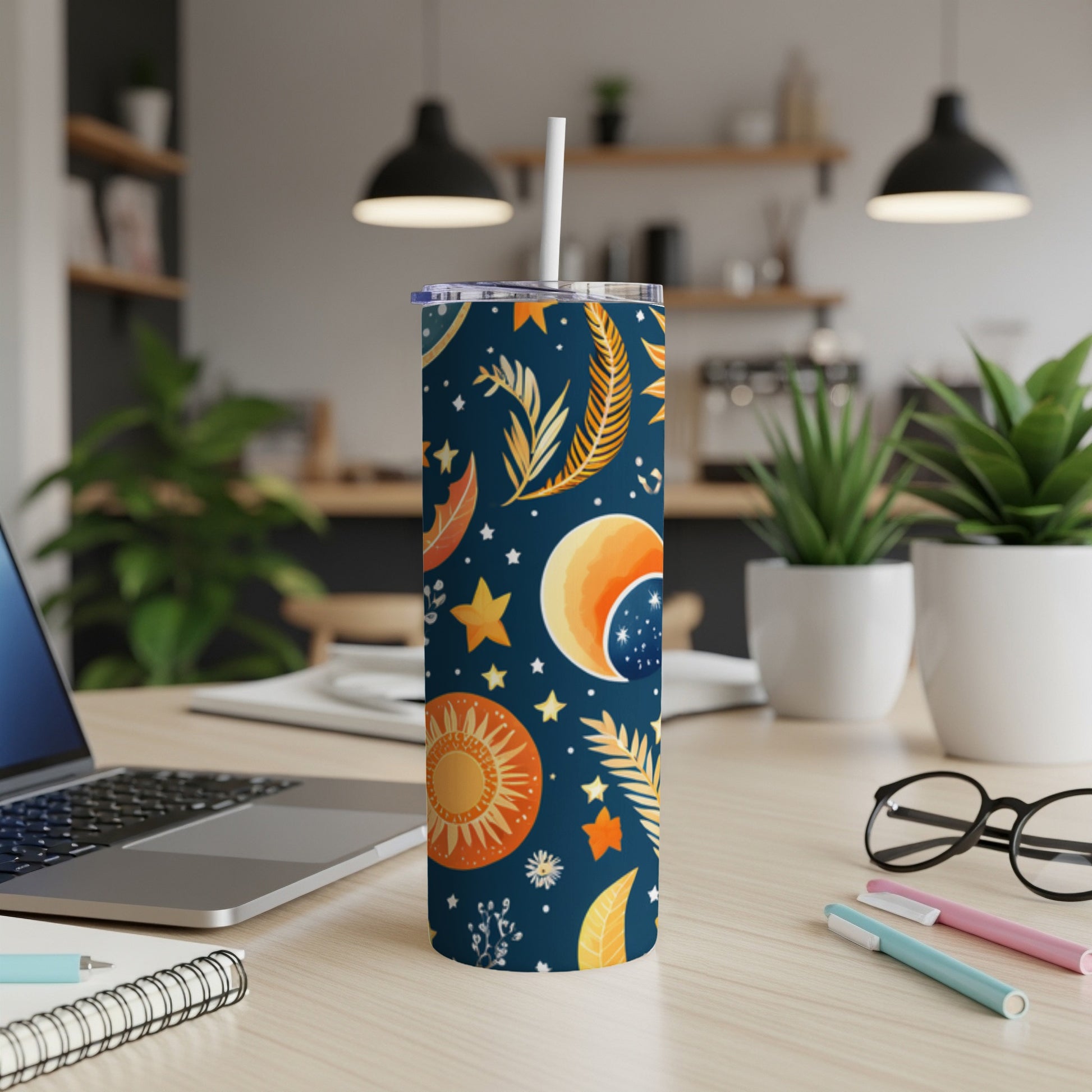 Dark blue tumbler with celestial sun, moon, and star pattern, includes straw.