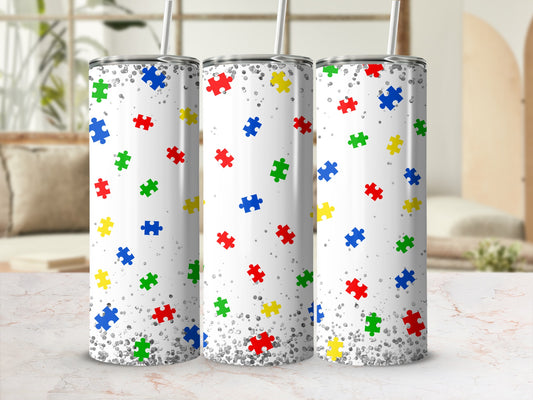 Three white tumblers with a colorful scattered puzzle piece pattern.