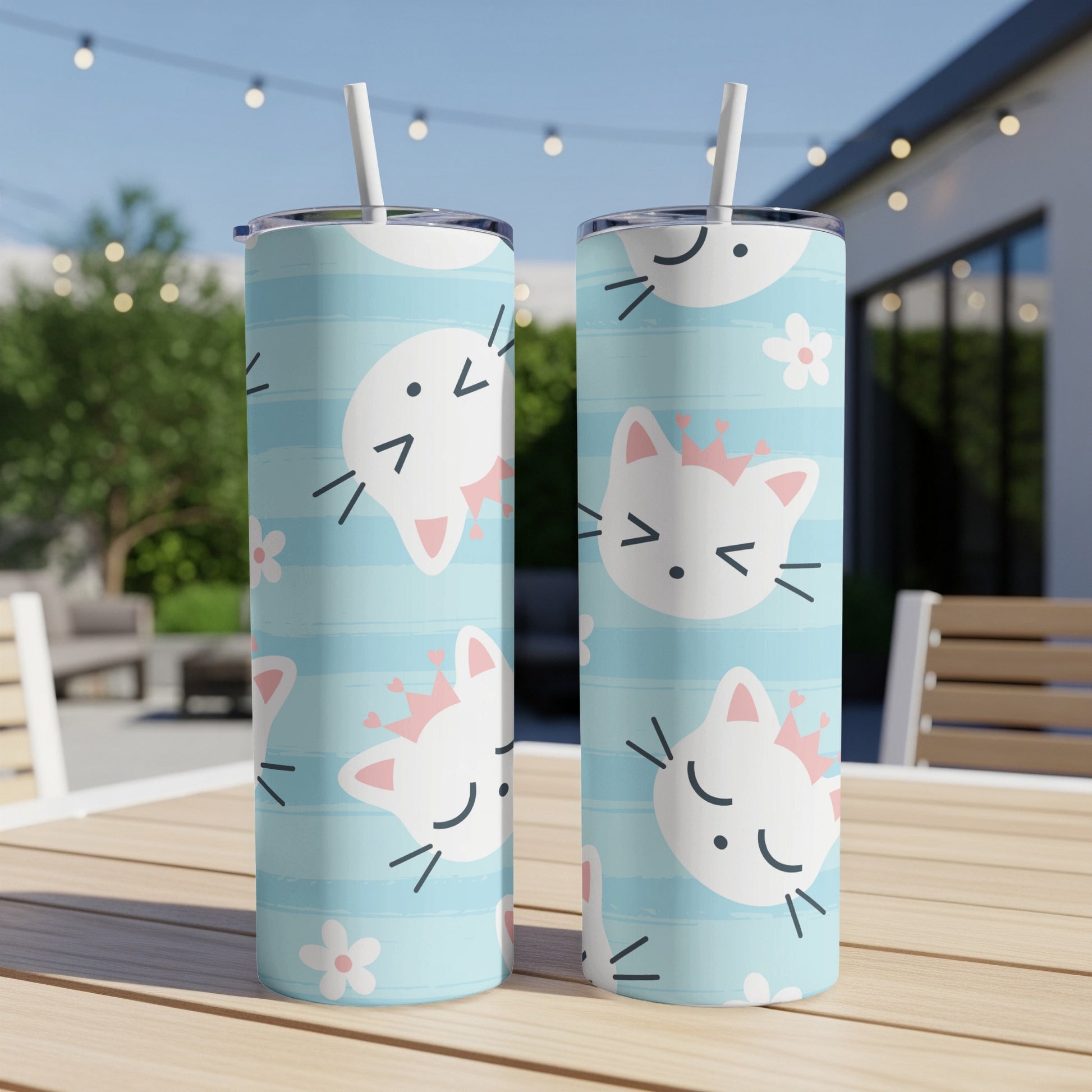 Two tumblers with a blue striped pattern and white cat faces wearing pink crowns.