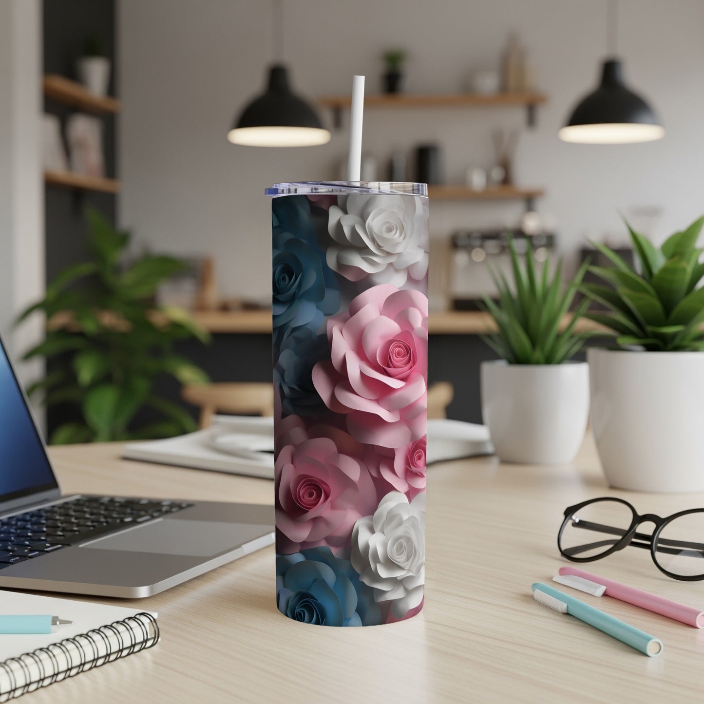 Tumbler with pink, blue, and white paper roses on a wooden desk.