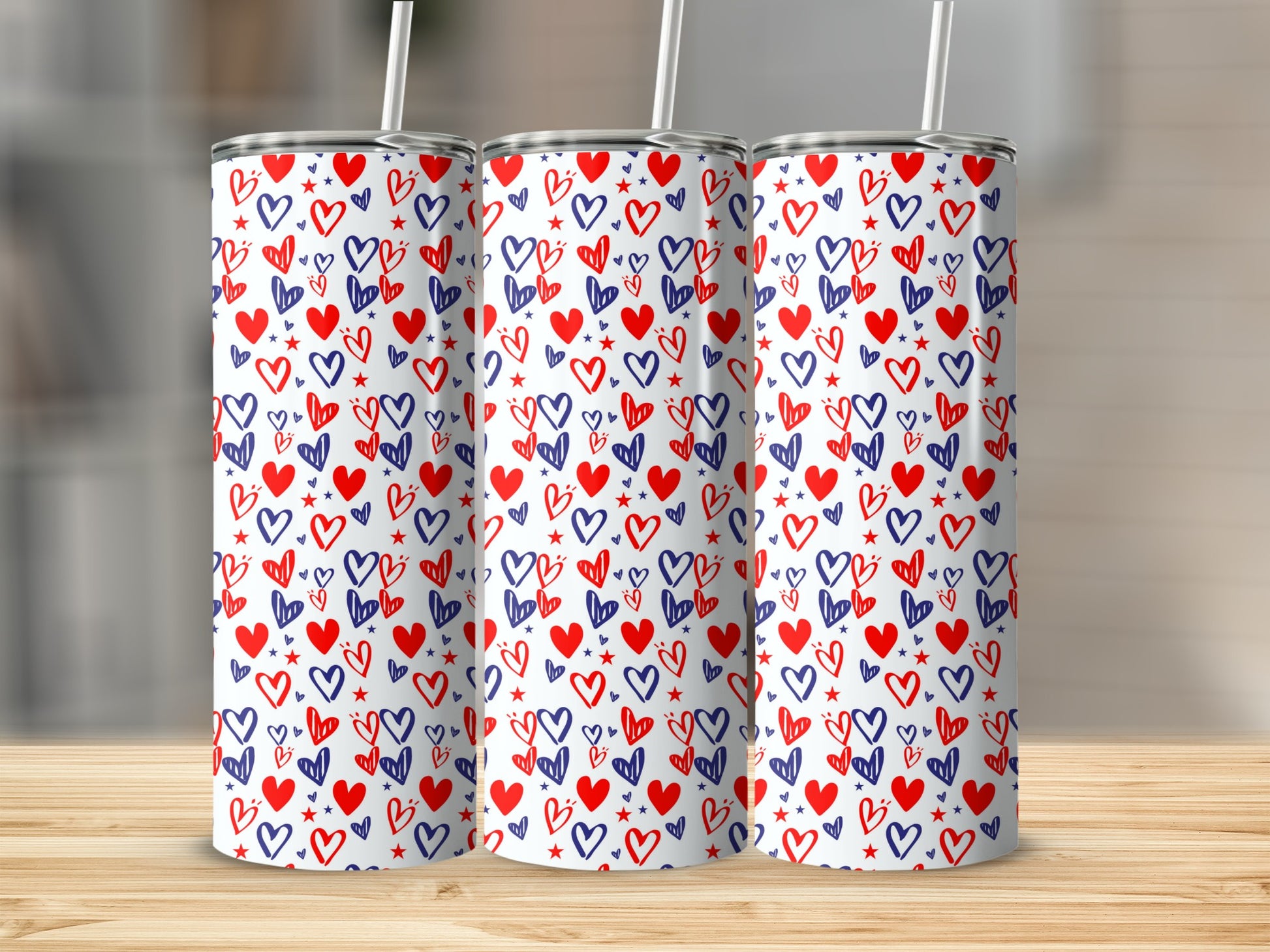 Three tall tumblers with a red and blue heart pattern on a wooden surface.