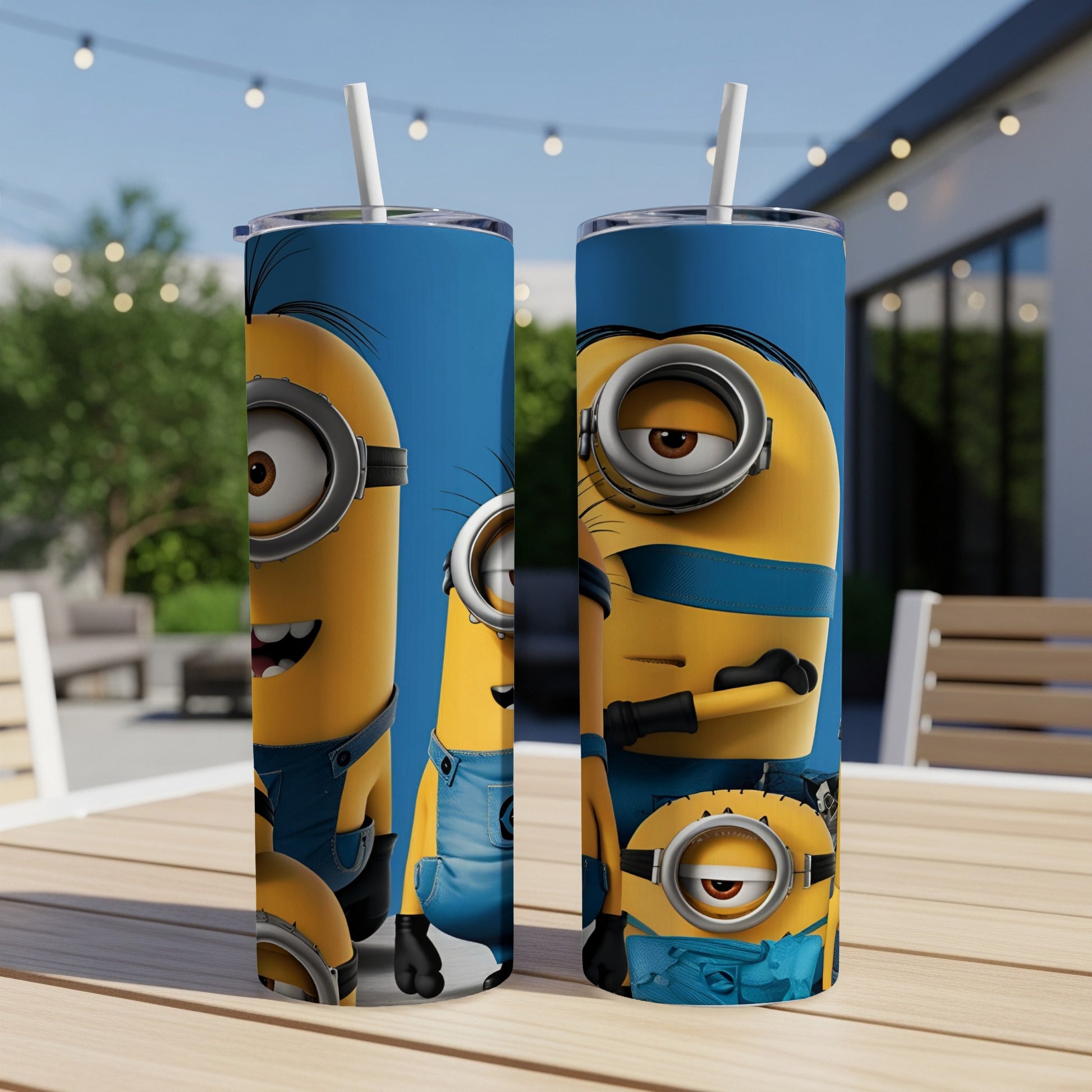 Two blue Minions tumblers with straws on a table outdoors.