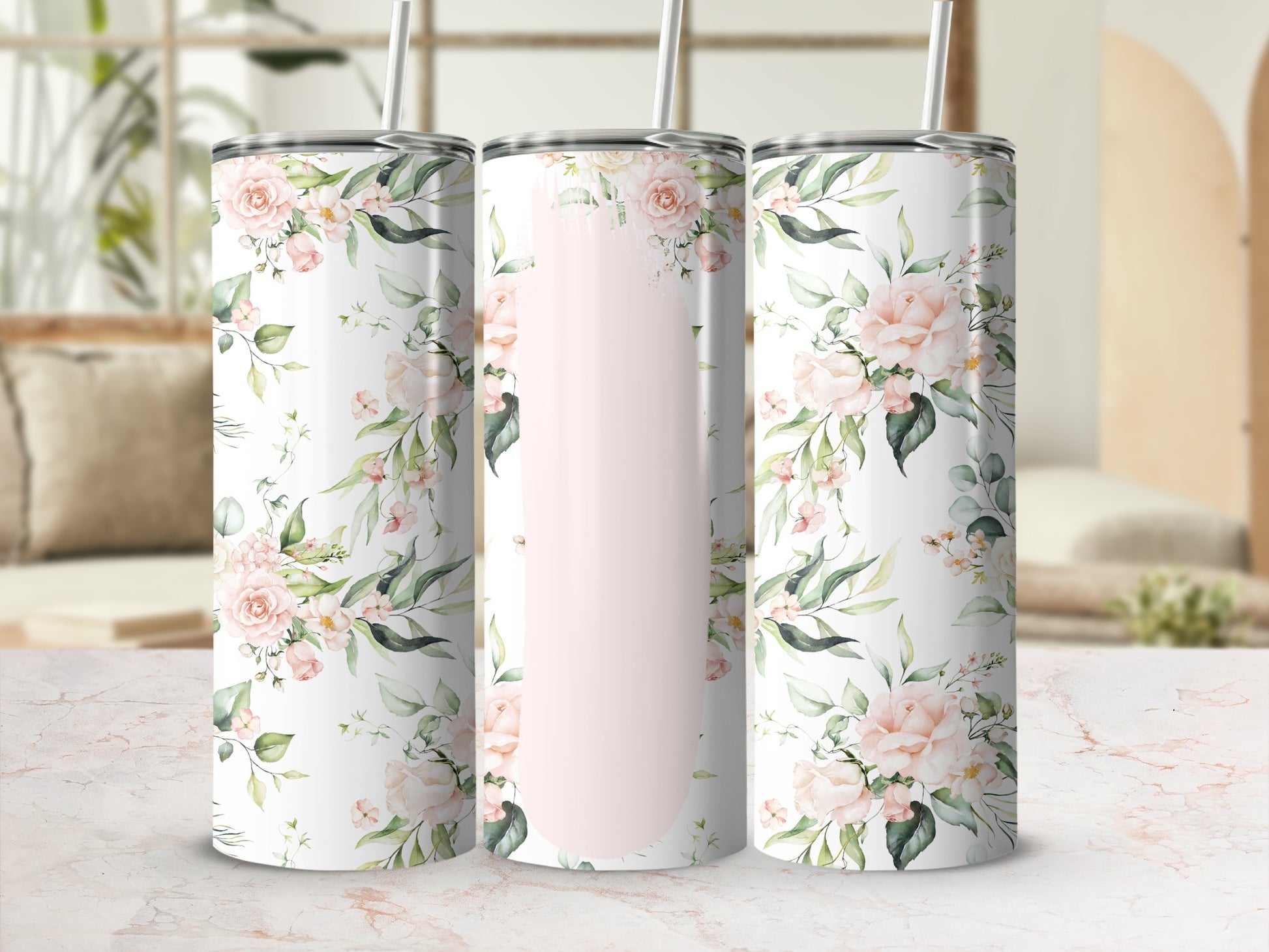 Pink floral design on three tumblers with straws.