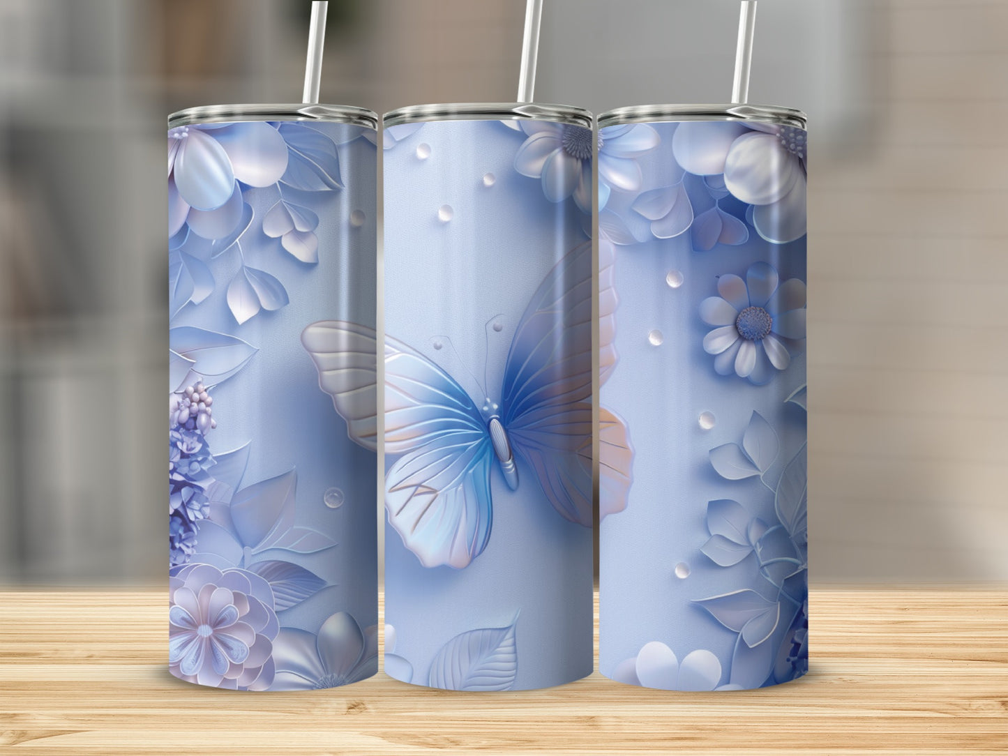 Blue tumbler with butterfly and floral design on wooden surface.