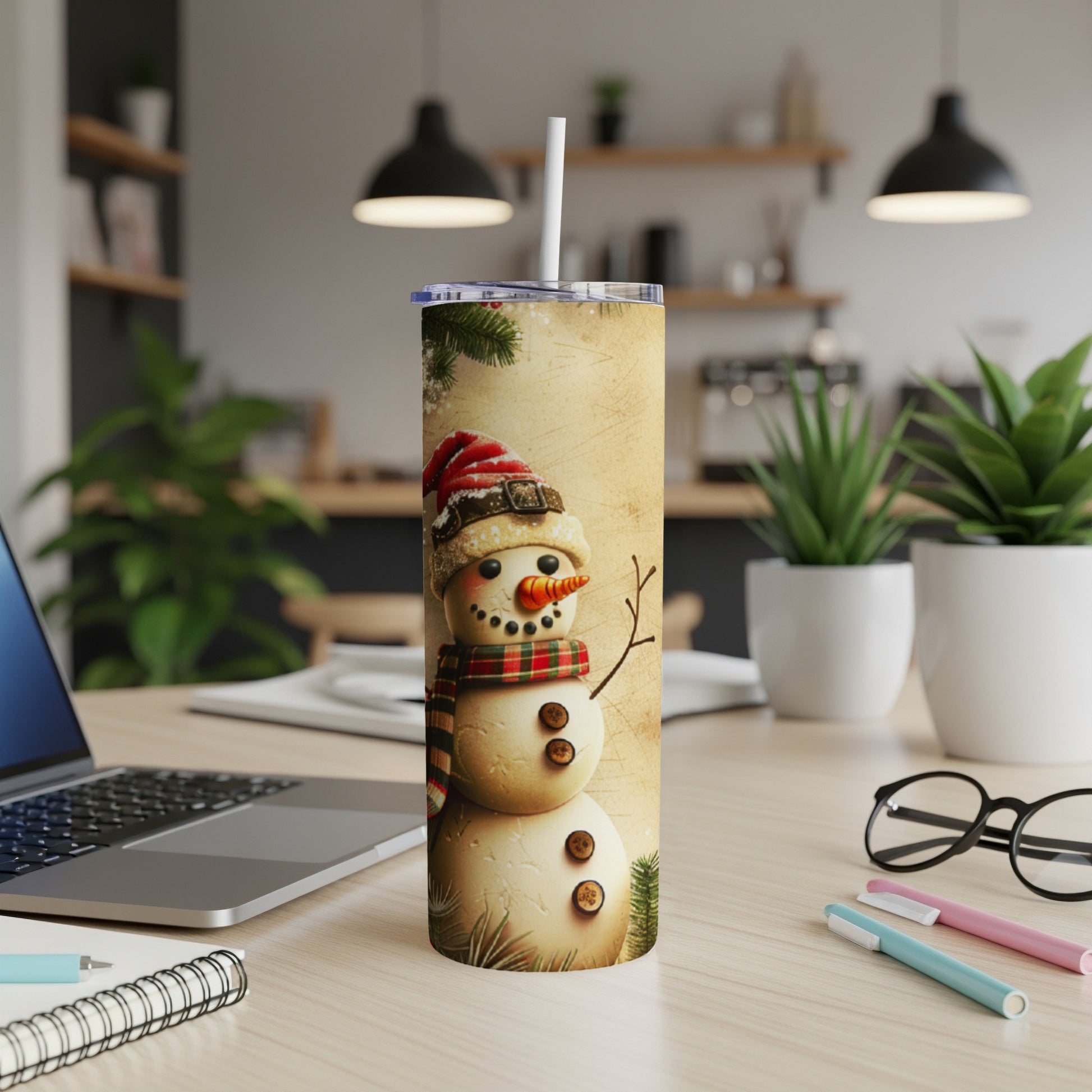 Snowman tumbler with festive hat and scarf on a desk.