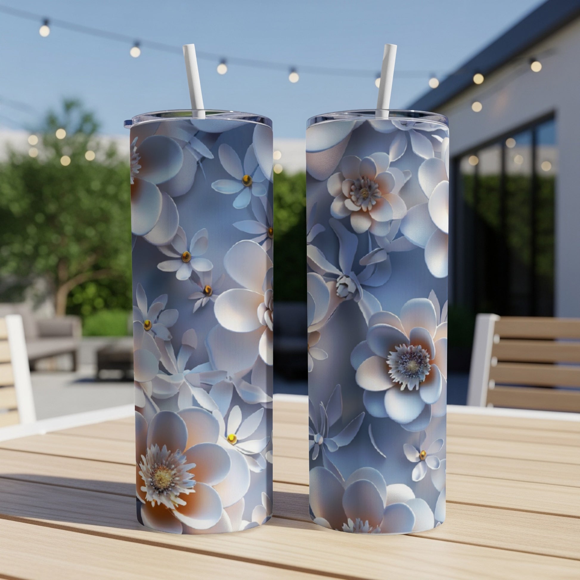 Two tall tumblers with a white floral pattern sit on a wooden table.