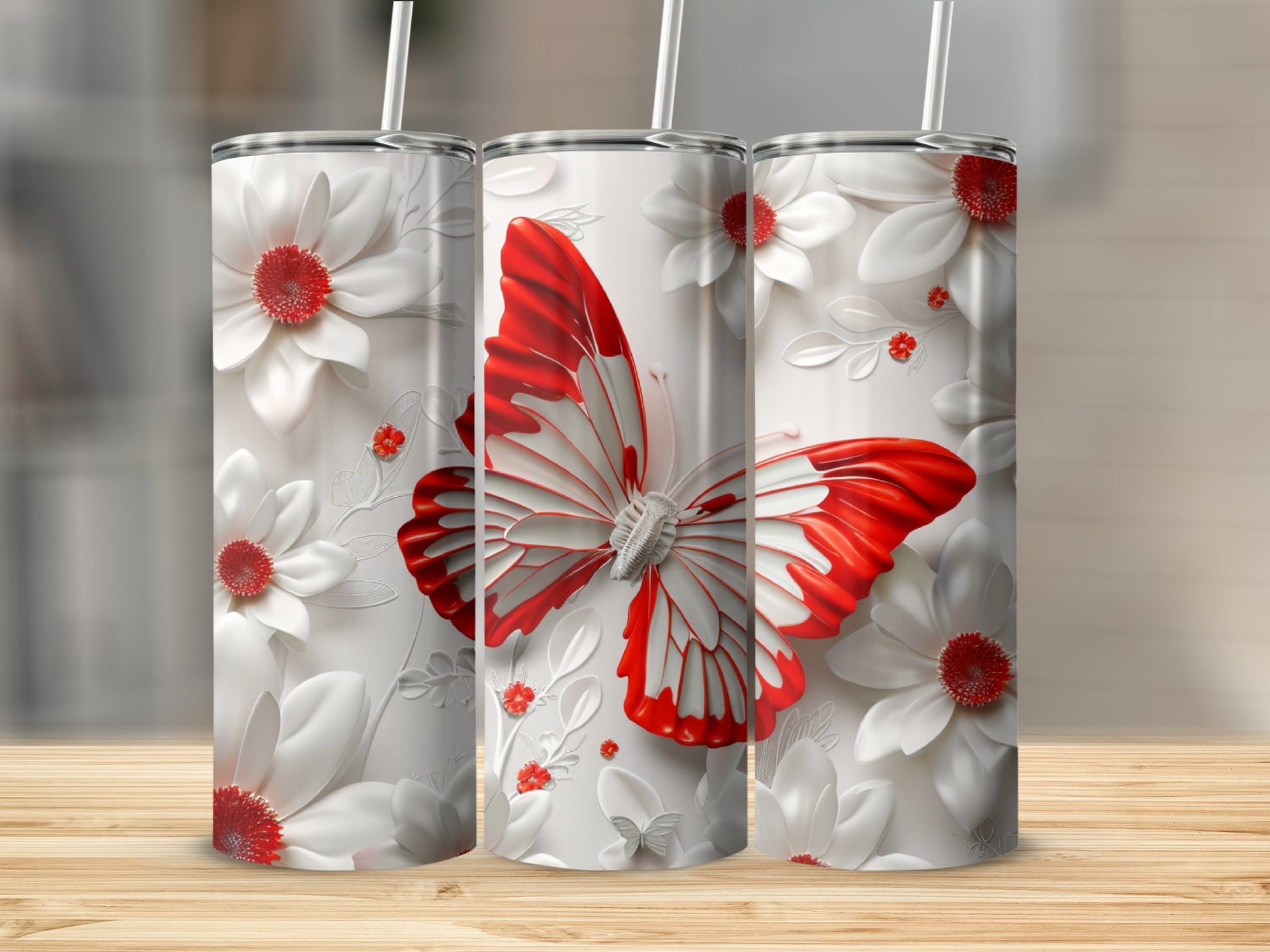 White tumbler with red butterfly and floral design, and two straws.