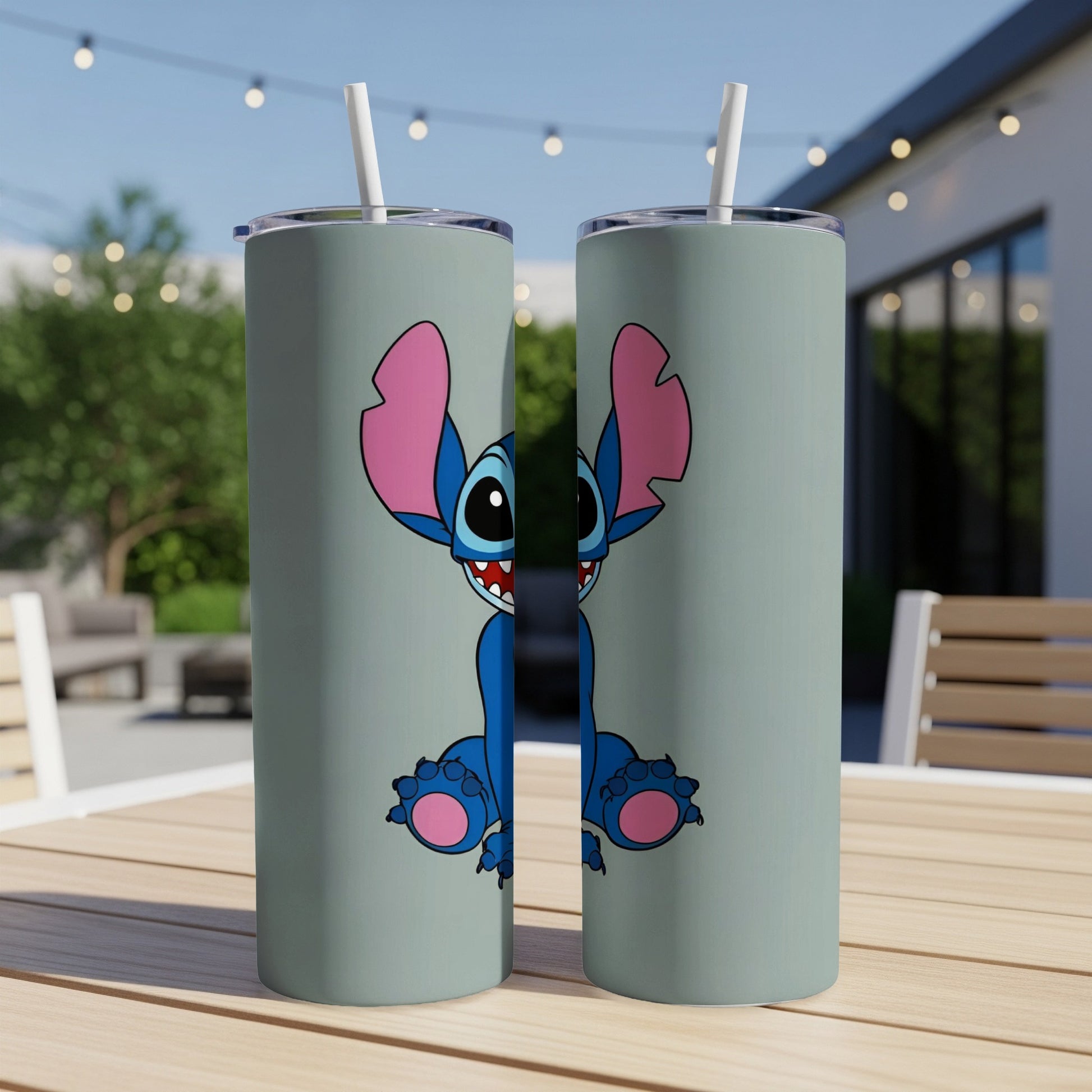Two mint green tumblers with Stitch cartoon character on a wooden table.