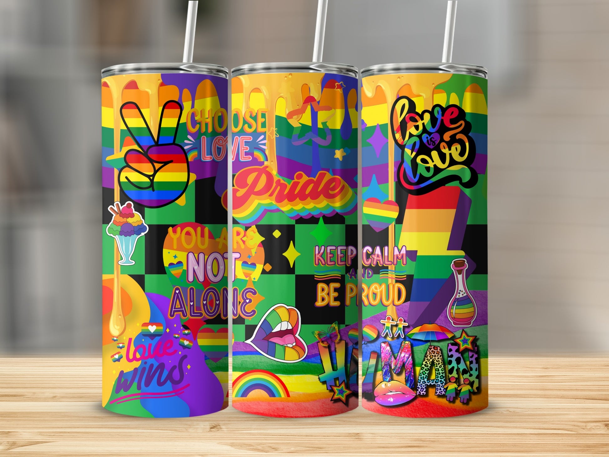 Three pride-themed tumblers with colorful graphics, hearts, and slogans like "Love Wins".