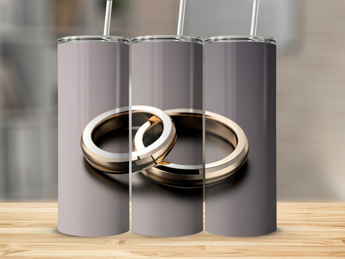 Two gold wedding rings with straws on a wooden surface.