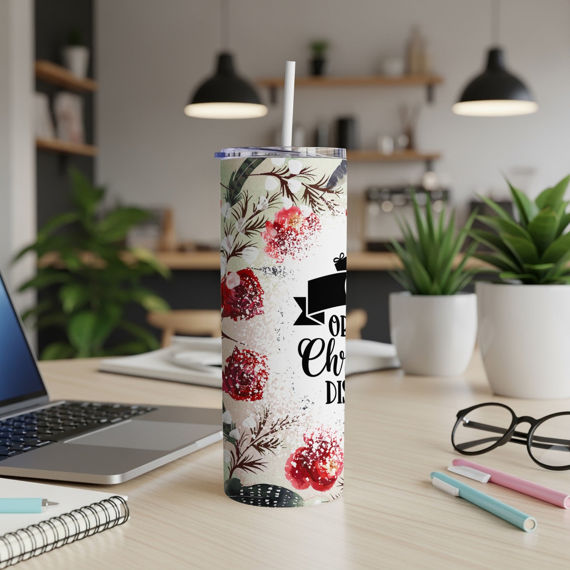 Floral tumbler with "Oh, Christmas Tree" text on a desk.