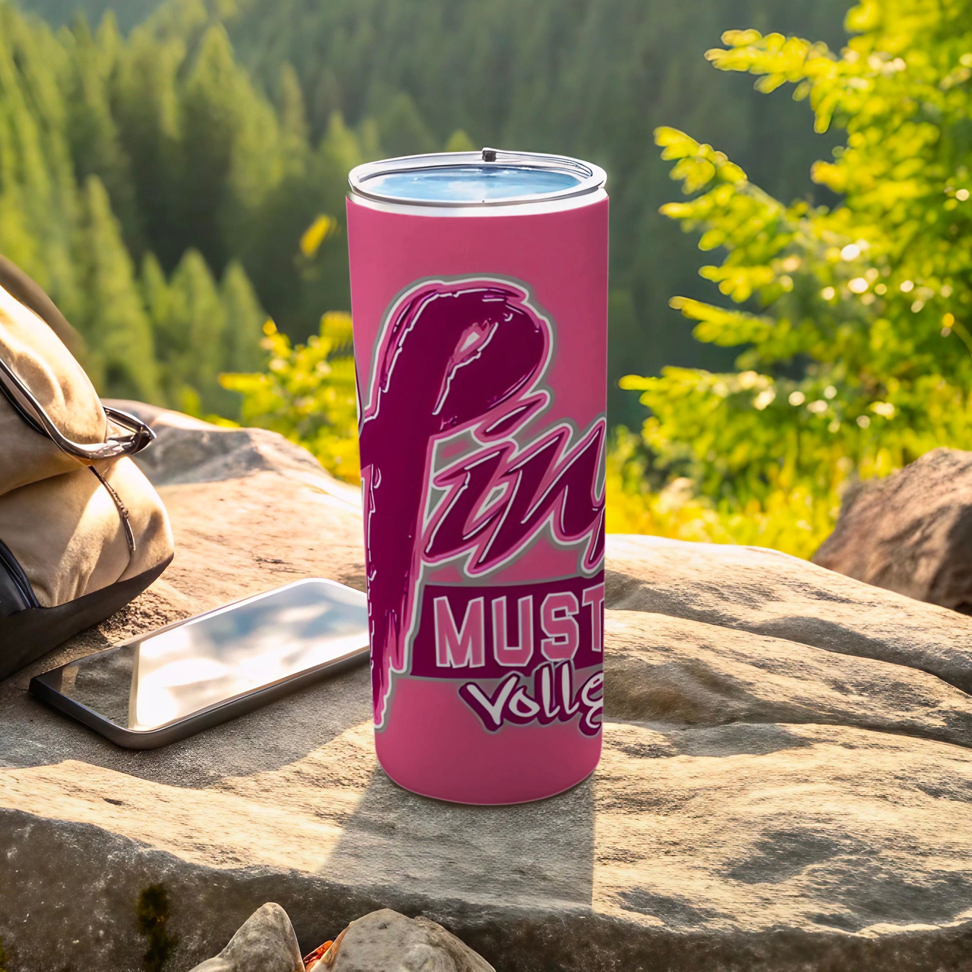 Pink tumbler with "Mustang Volleyball" text in cursive, on a rock.