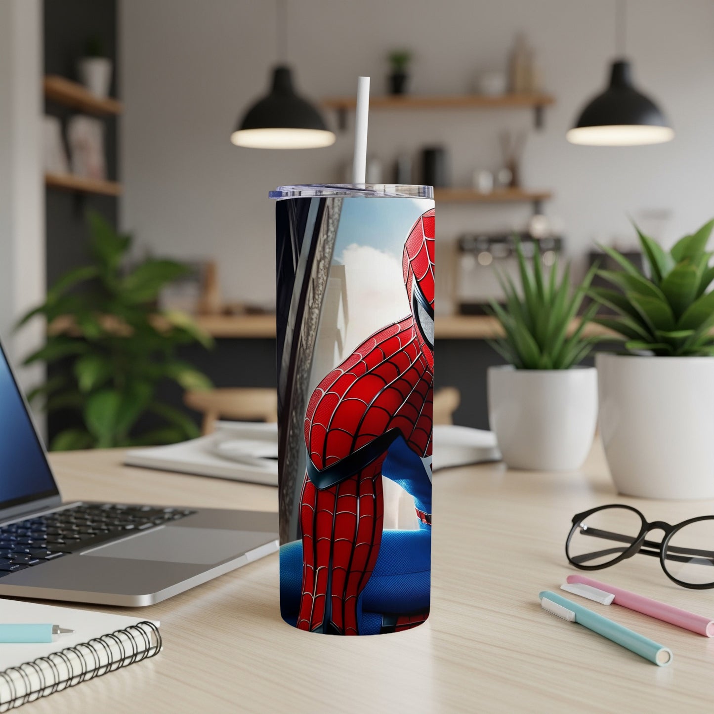 Spider-Man tumbler with straw on a desk.