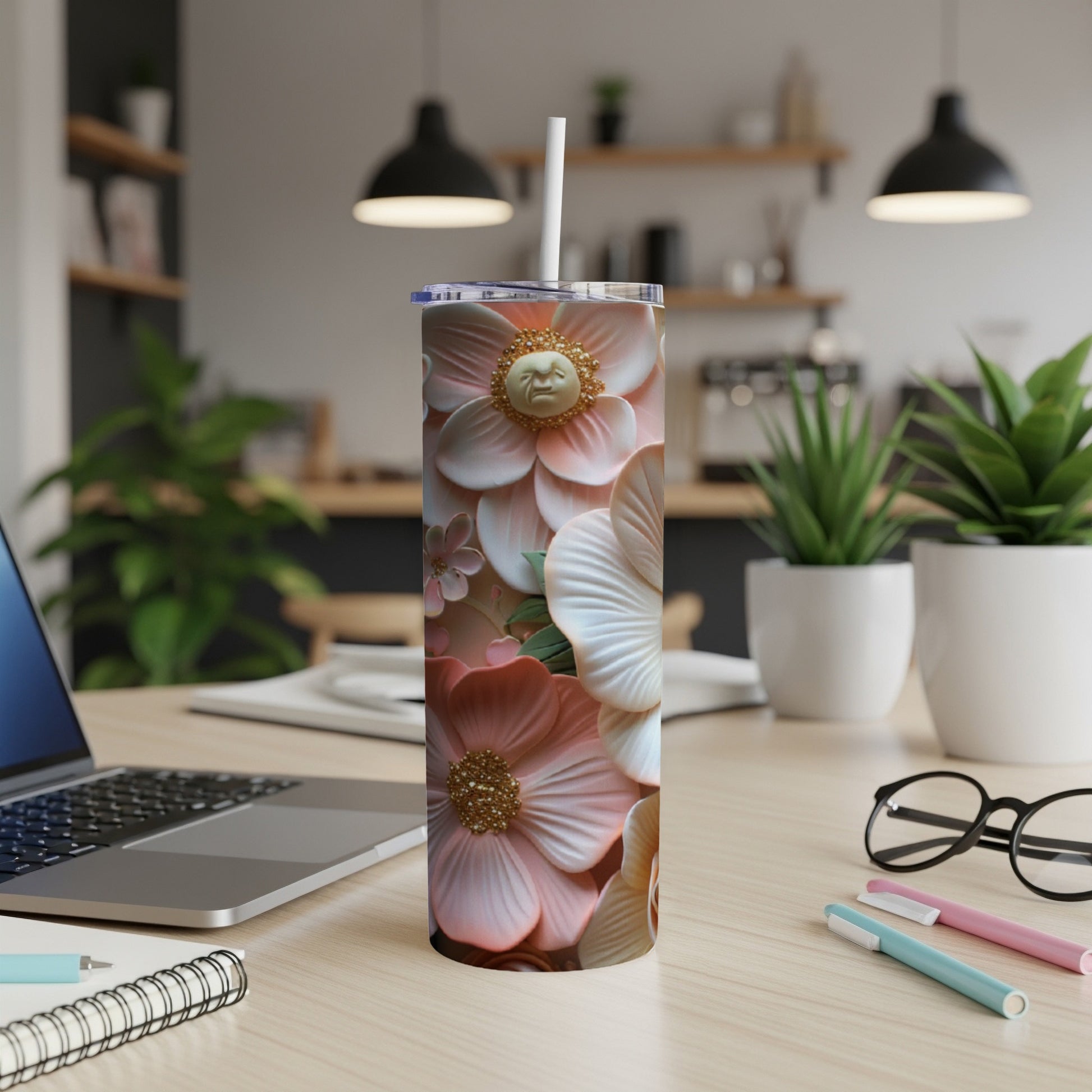 Tall tumbler with intricate floral pattern and straw on a desk.
