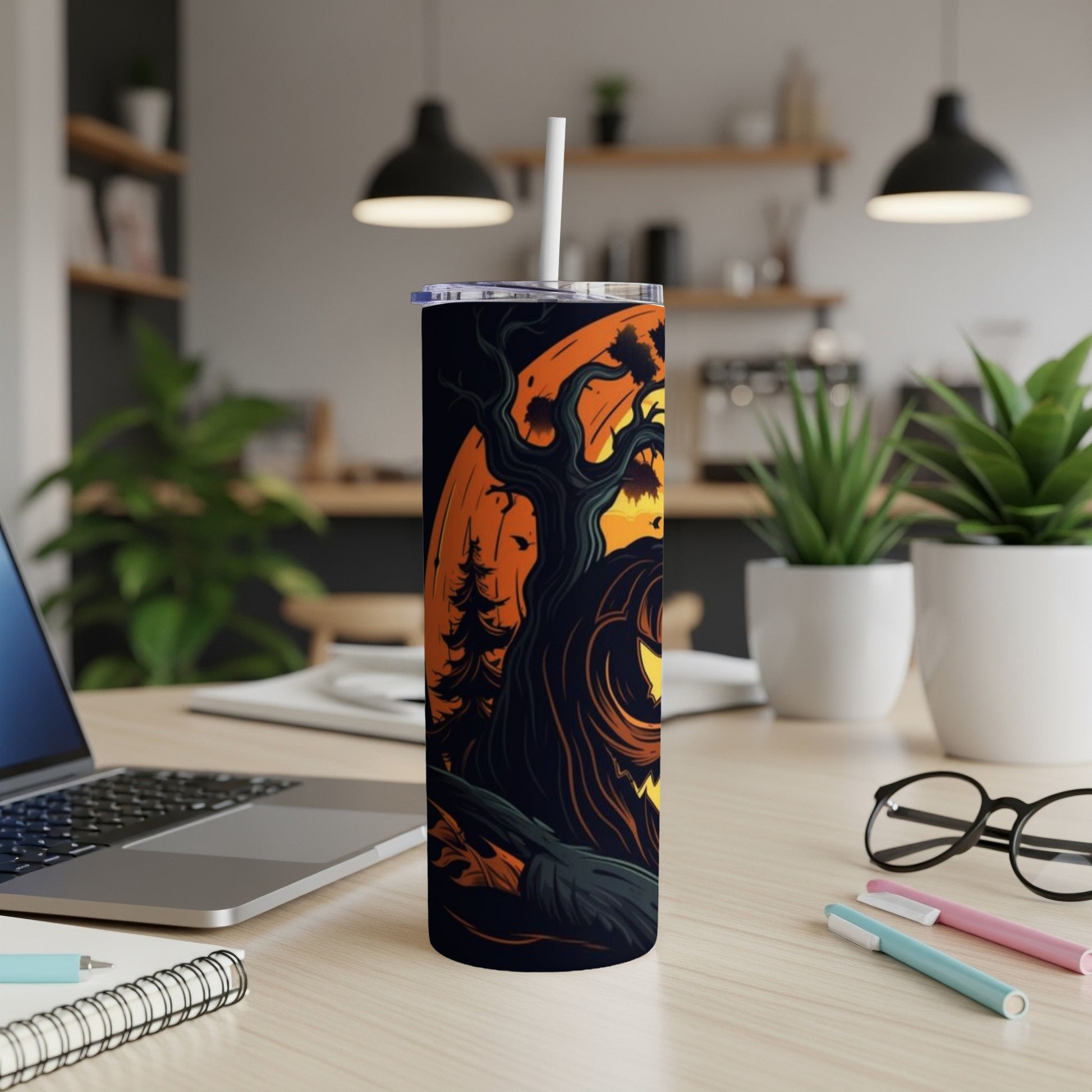 Tumbler with Halloween tree and jack-o'-lantern design, with straw and lid.