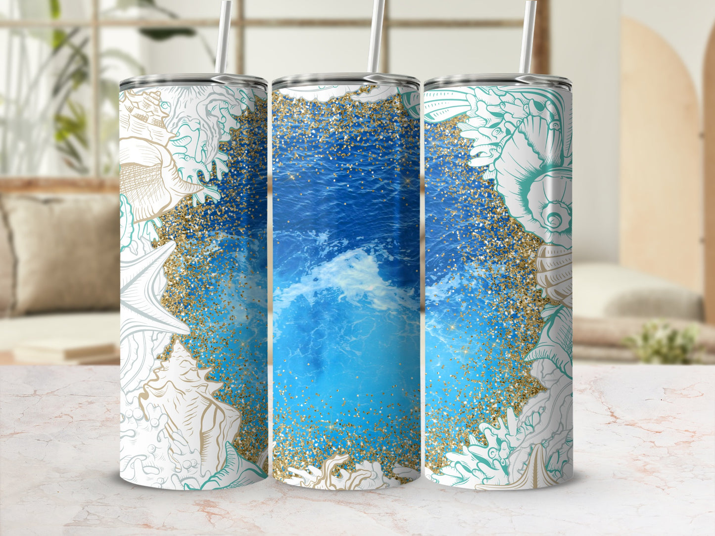 Three tumblers with seashell and ocean wave designs and gold glitter.