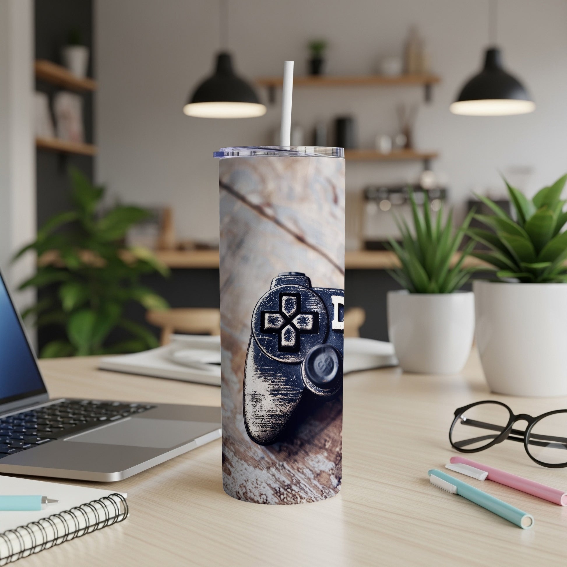 Video game controller on wood grain tumbler with office desk in background.