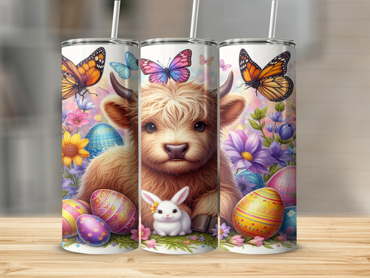 Highland cow with butterflies, bunny, and Easter eggs on a tumbler.