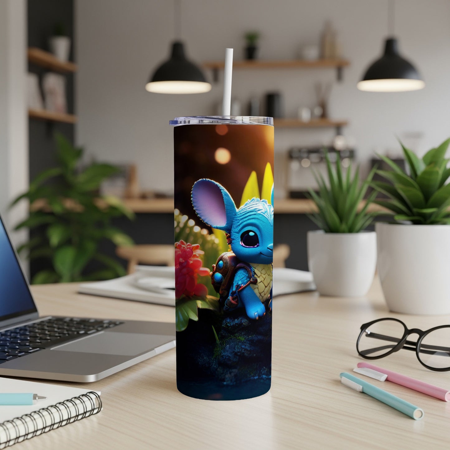 Blue alien creature on tumbler, with straw, on desk.