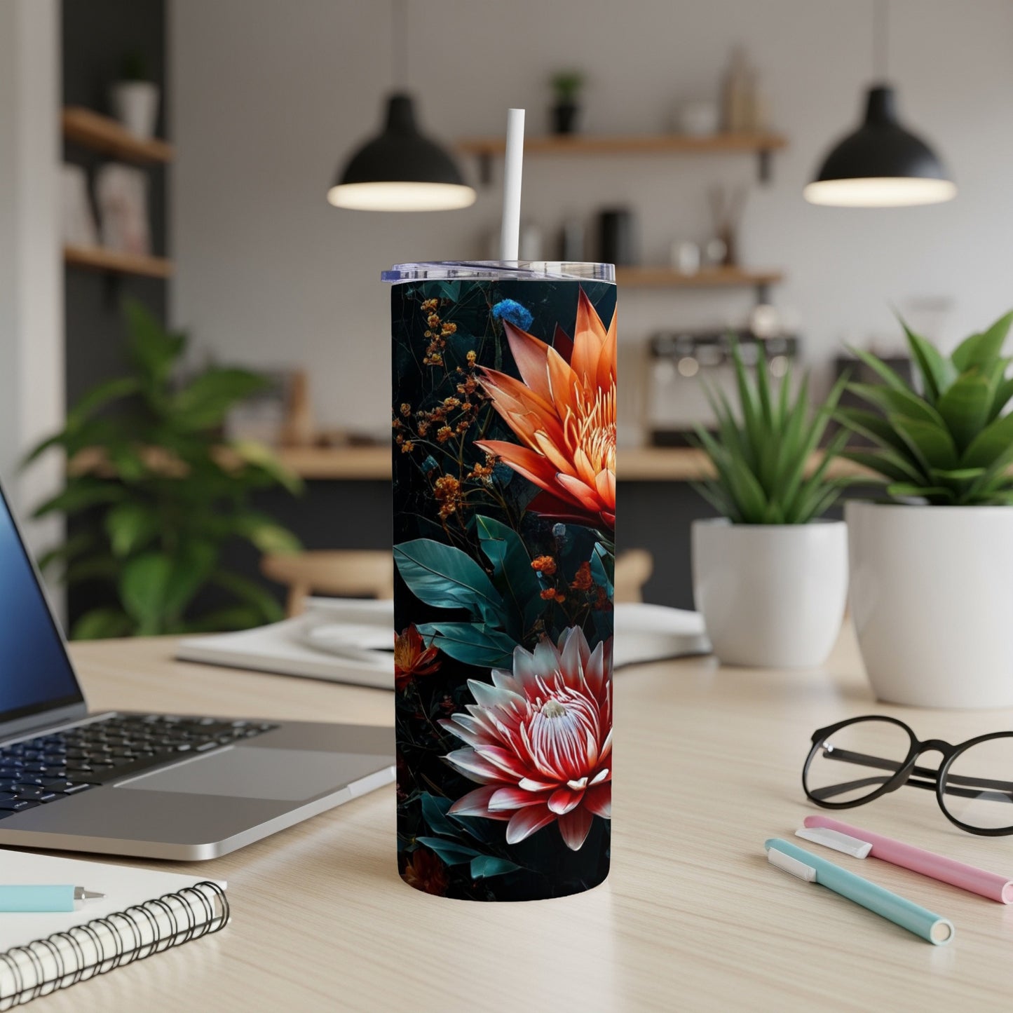 Floral tumbler with orange and pink flowers on a wooden desk.