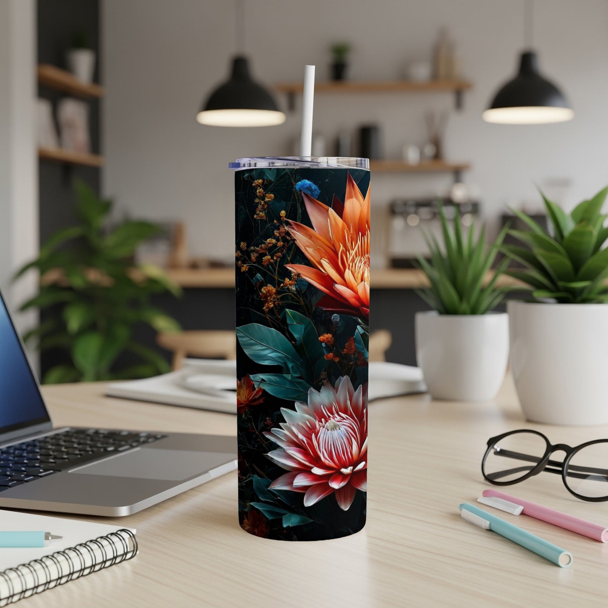 Floral tumbler with orange and pink flowers on a wooden desk.