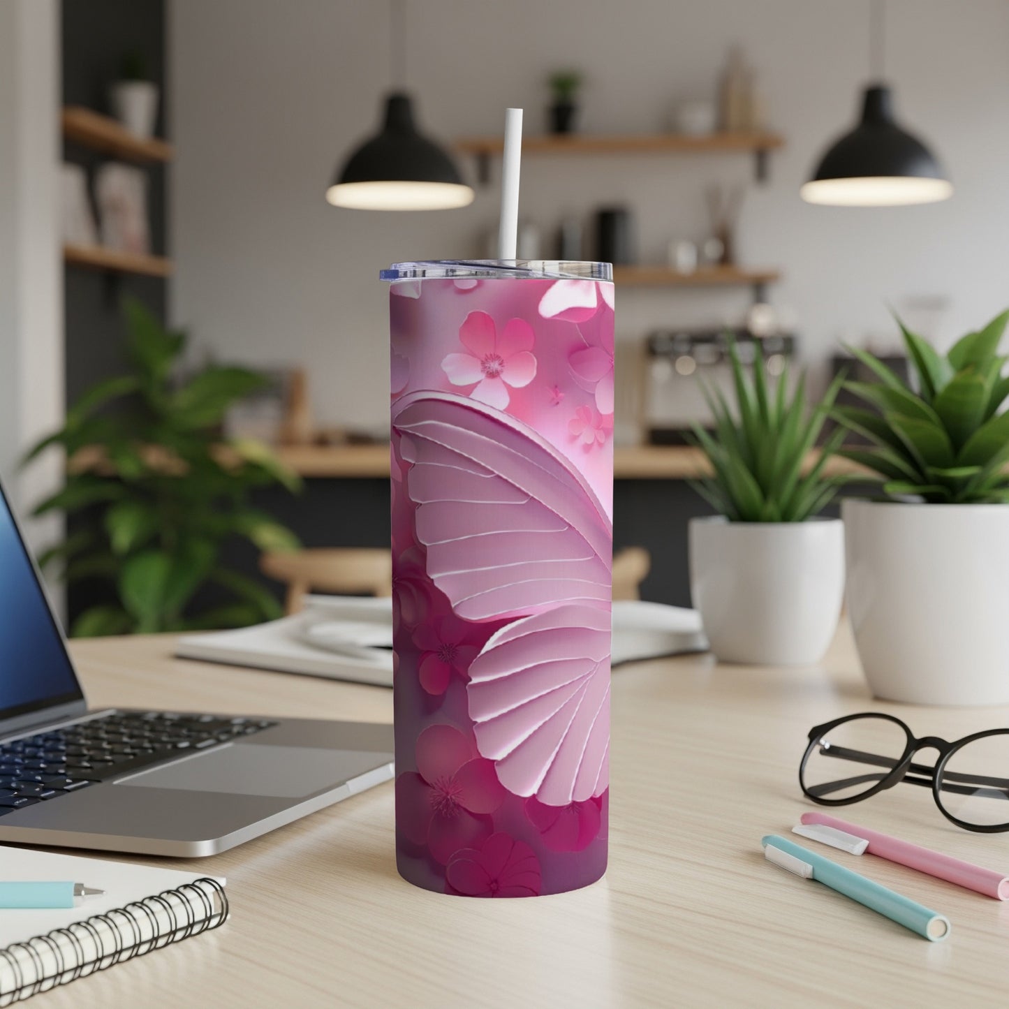 Pink butterfly and floral design on a skinny tumbler with a straw.