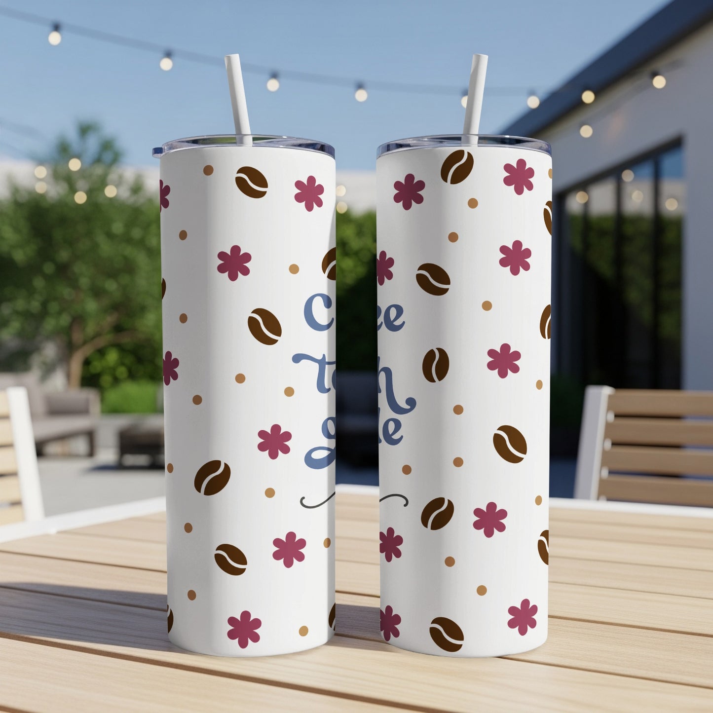 Two white tumblers with coffee beans and flowers on a wooden table.