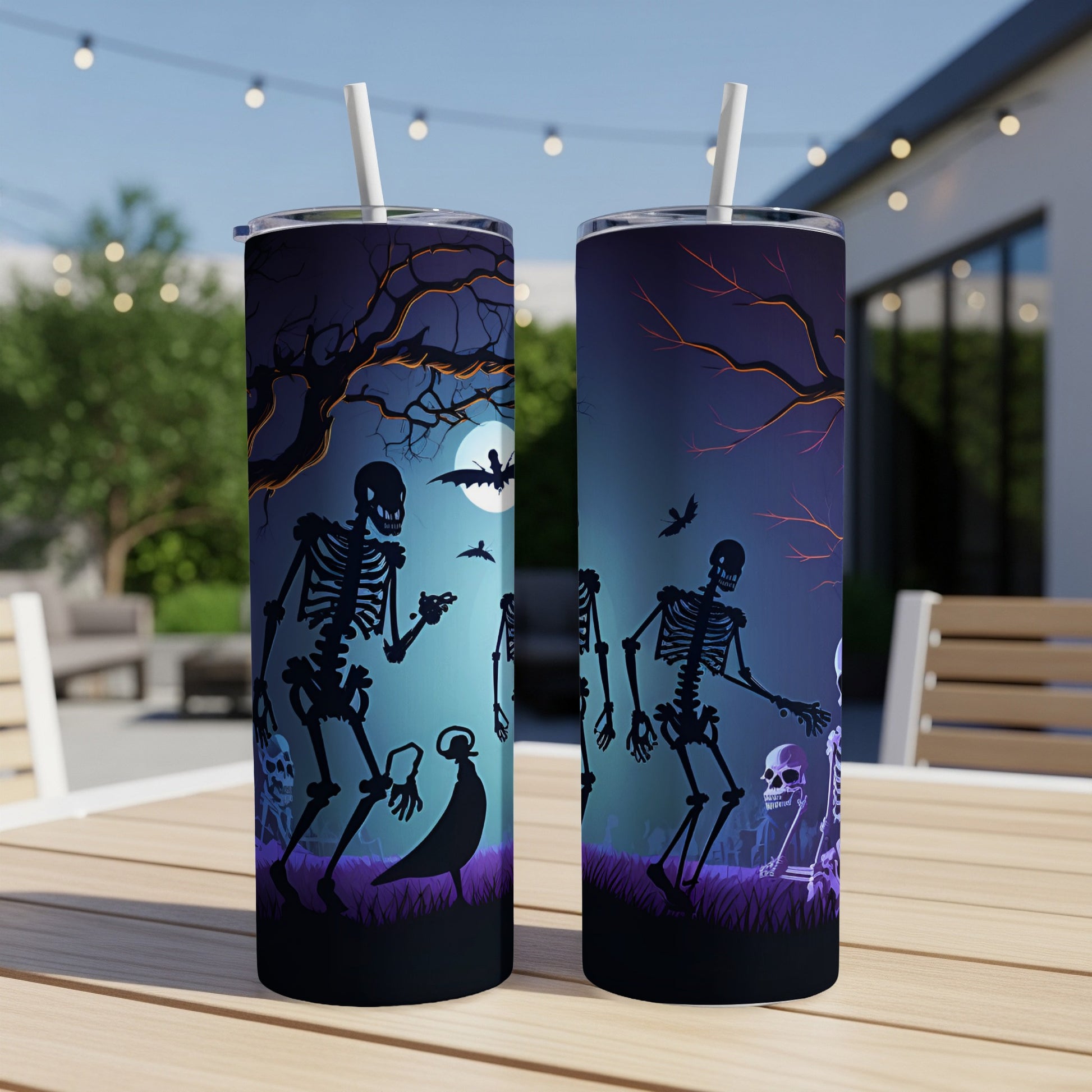 Two tumblers with a Halloween graveyard scene featuring skeletons, bats, and a moon.